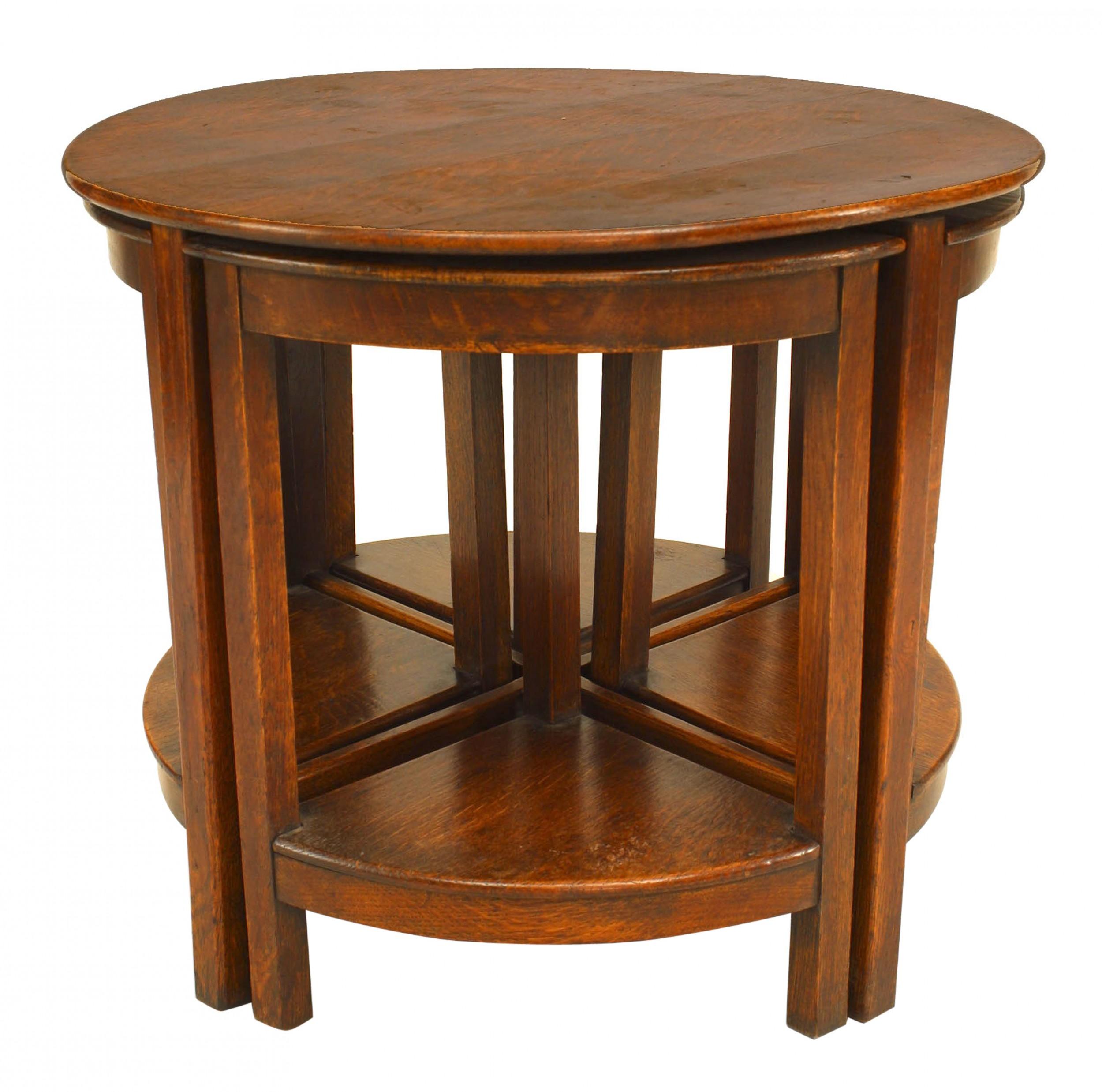 English Arts & Crafts dark stained oak round table fitted with 4 nesting triangular tray stools.
  