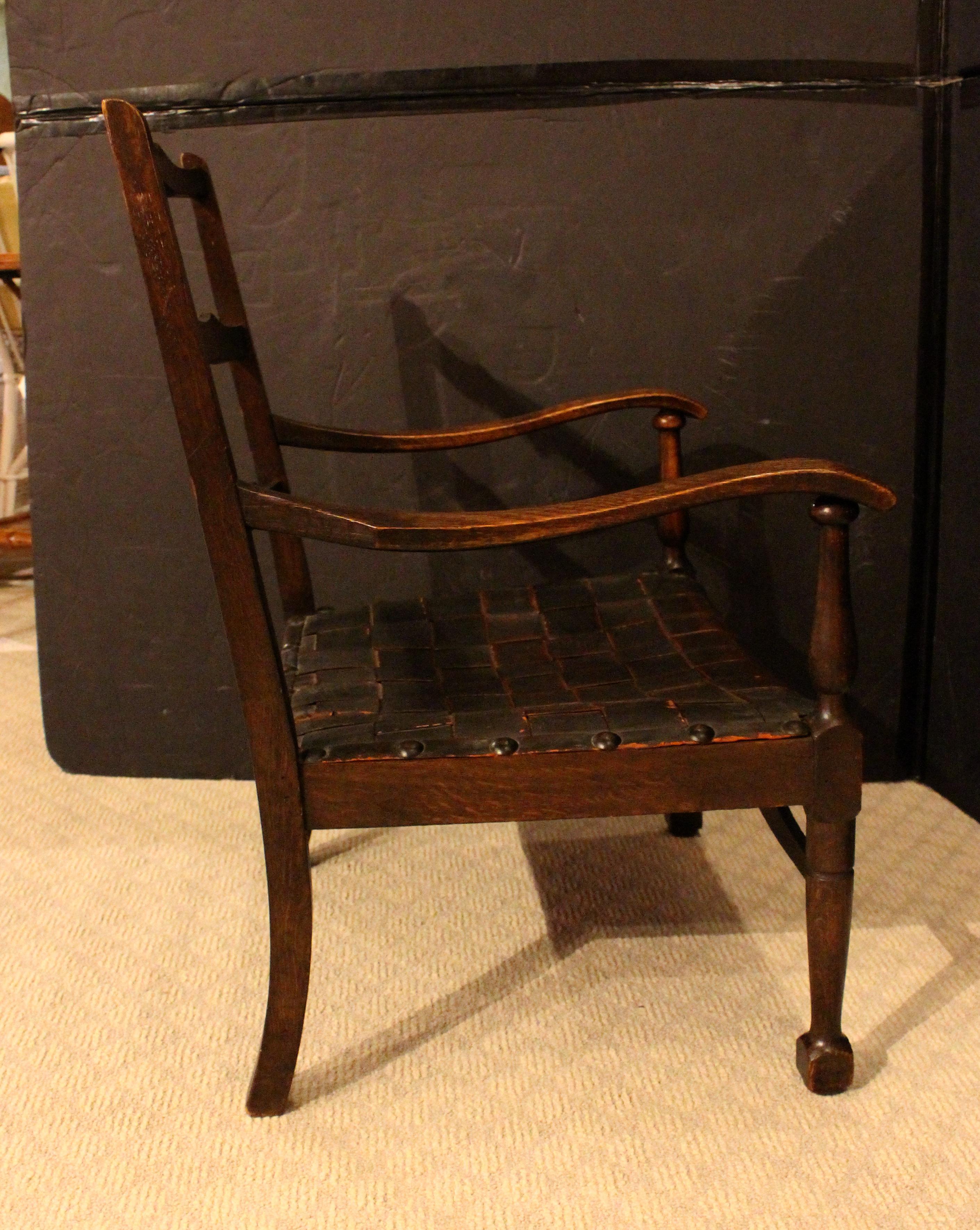 Englischer Arts & Crafts Slipper Arm Chair, um 1885. Ein selten gefundenes Exemplar aus Ulme und Eiche mit originalem ledergeflochtenem Sitzband. Große Nieten verankern das Leder. Gedrechselte, sich verjüngende Beine zu quadratischen Blockfüßen. 22