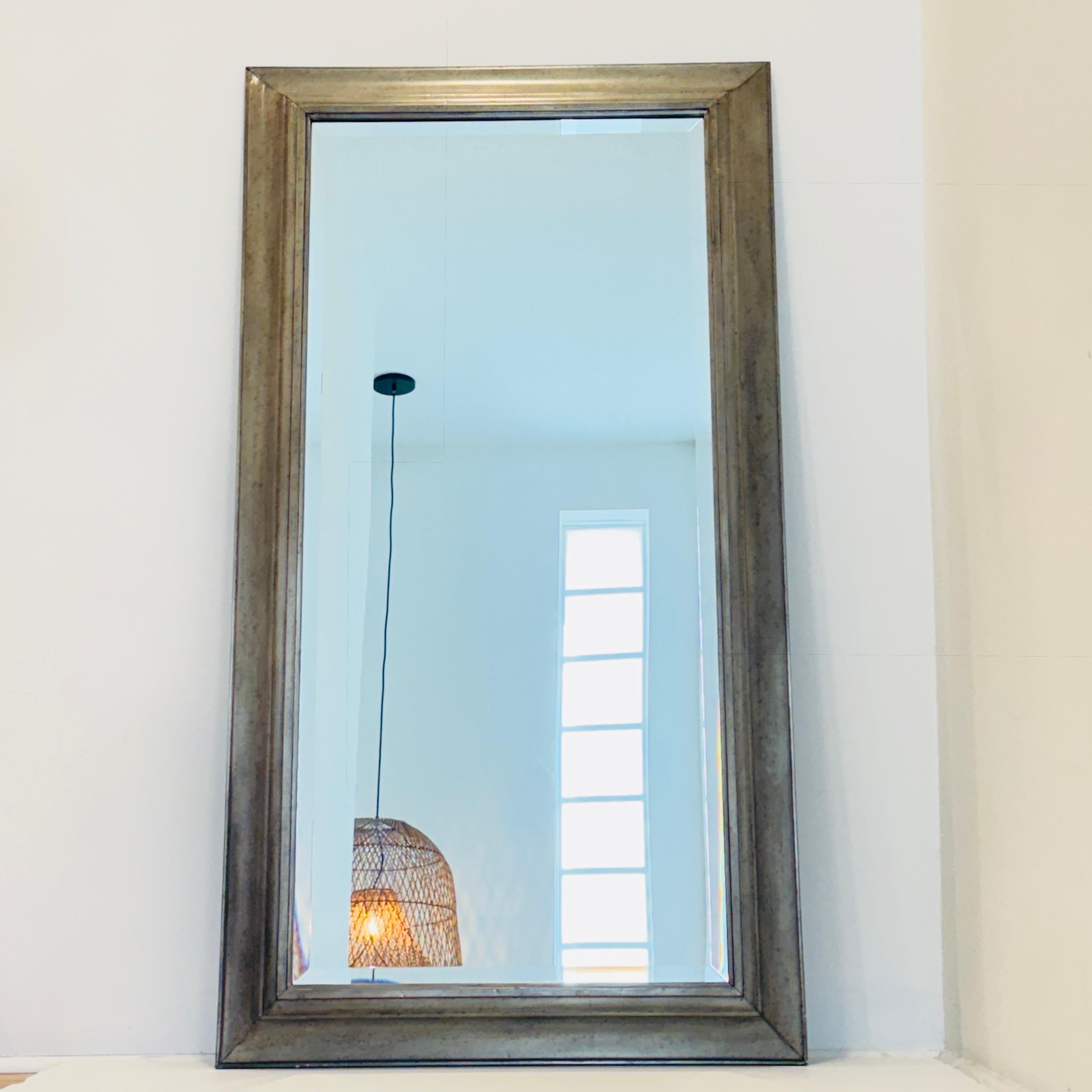 Specchio in stile inglese realizzato in legno massiccio e rivestito in nichel. La cornice rettangolare ha una finitura in nichel antico e presenta cuciture accuratamente lavorate, con vetro smussato al centro e supporto in legno.  La cornice pesante