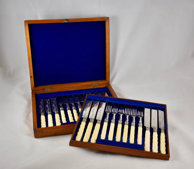 A service for 12, cream colored English Bakelite, knobbed handled, silver-plate, dessert sized flatware set in the original box, circa 1920s.

This unusual handled twenty-four-piece set has 12 each, forks and knives, in the original two-tiered felt