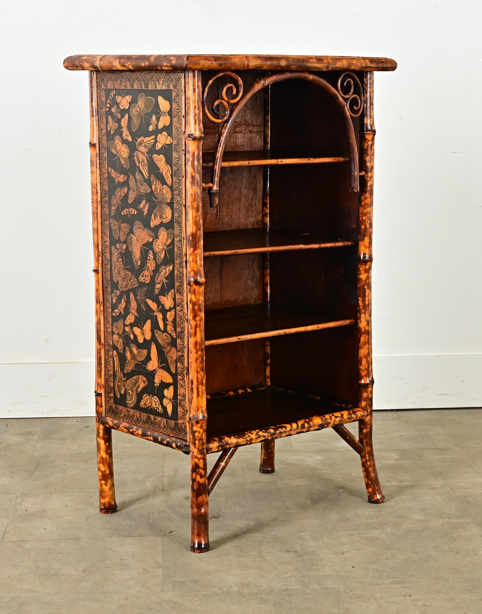 A unique and cheerful little bamboo bookcase from 19th century England. This antique bookshelf has been recently refinished with a black and gold decoupage butterfly motif that is similar to the color of the bamboo’s finish. It has three fixed