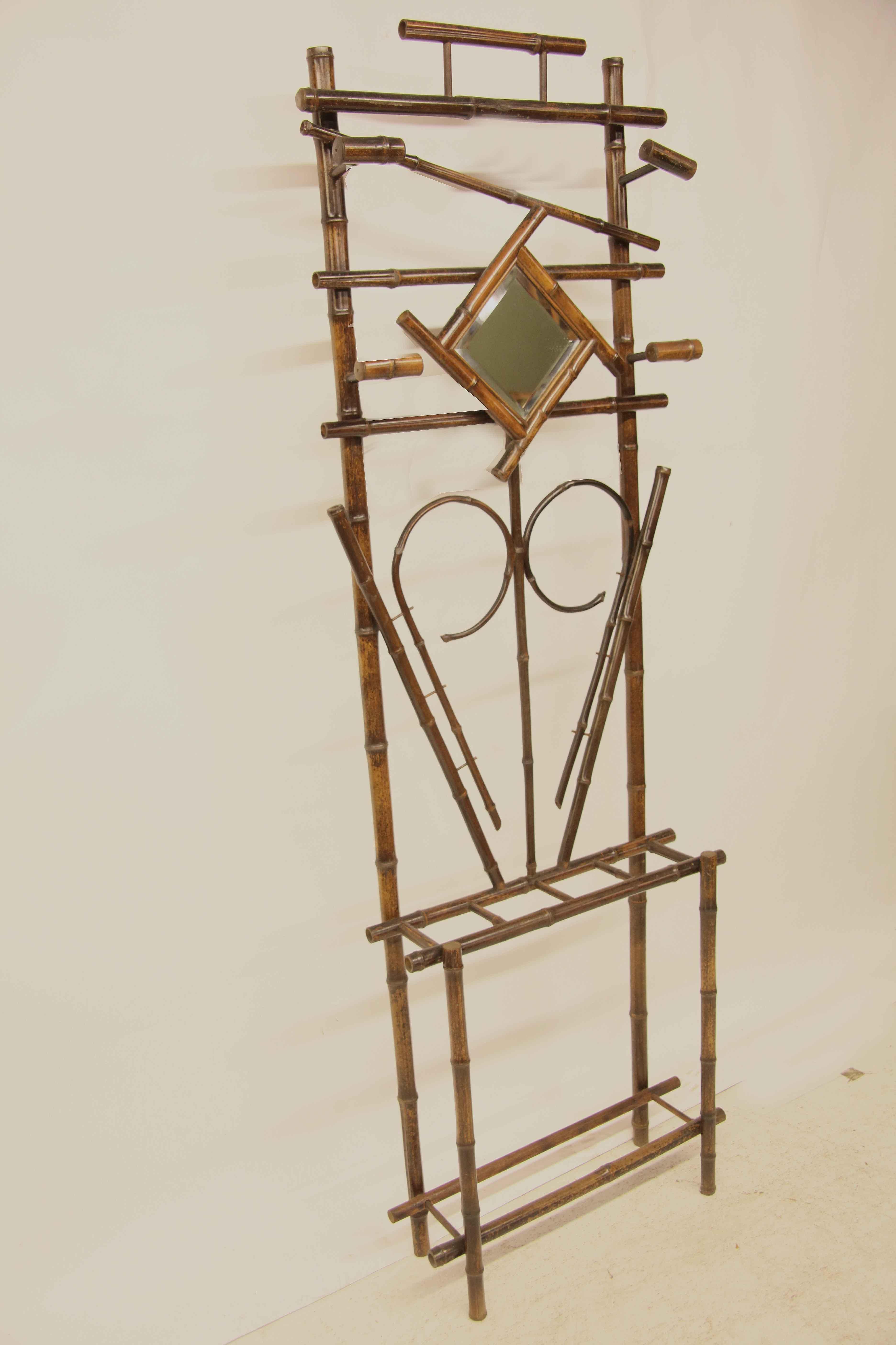 English bamboo hall stand, upper portion with four bamboo coat or hat holders and original beveled glass mirror, lower portion with four divisions for canes or umbrellas.