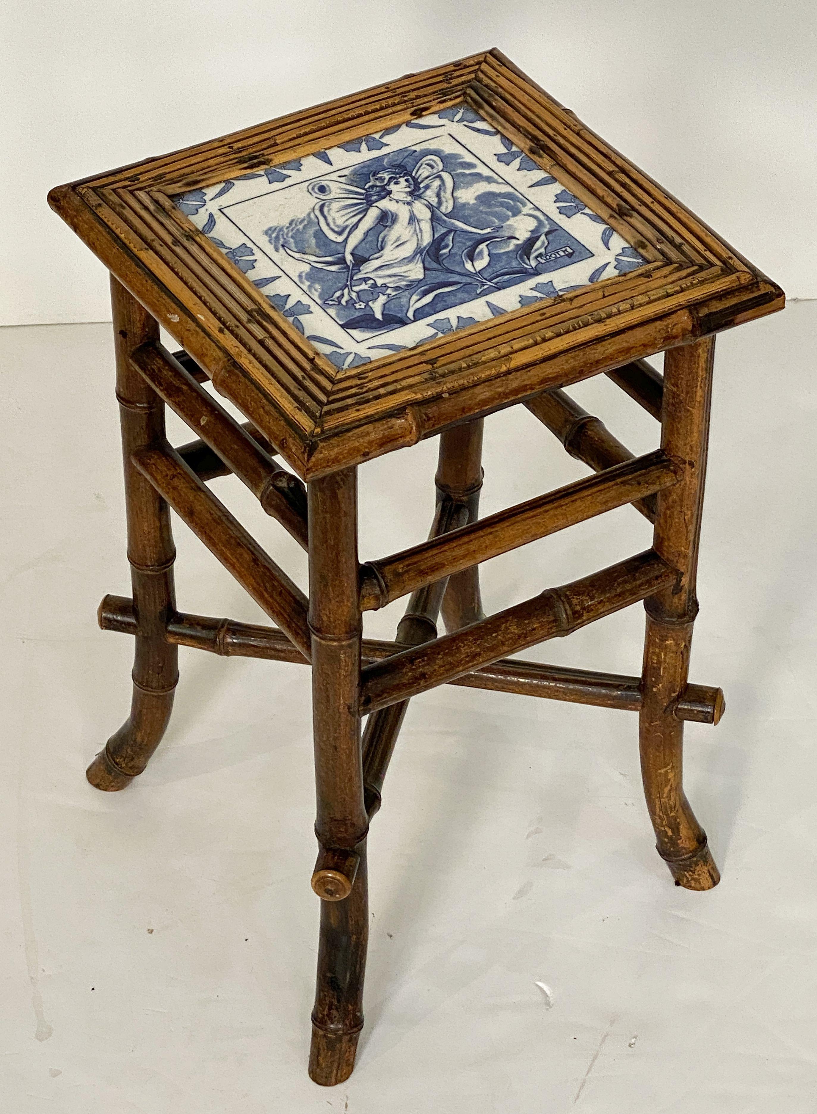 A fine English bamboo table or stool from the Aesthetic Movement period of the late 19th century, featuring a handsome patinated finish and square seat of bamboo with inset blue and white ceramic tile by Wedgwood of the faerie (or fairy), Moth, from