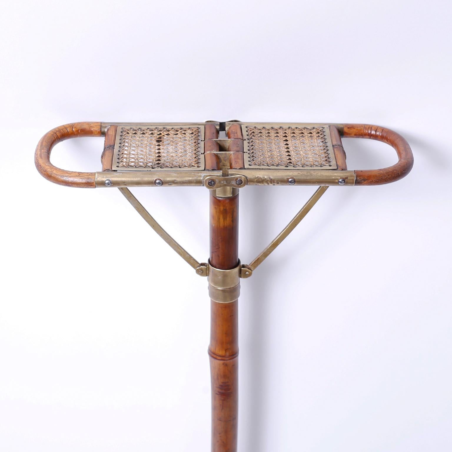Rare antique English bamboo walking stick with a fold out caned seat, polished brass mechanism, and iron spike. Sometimes called a polo or hunting seat.