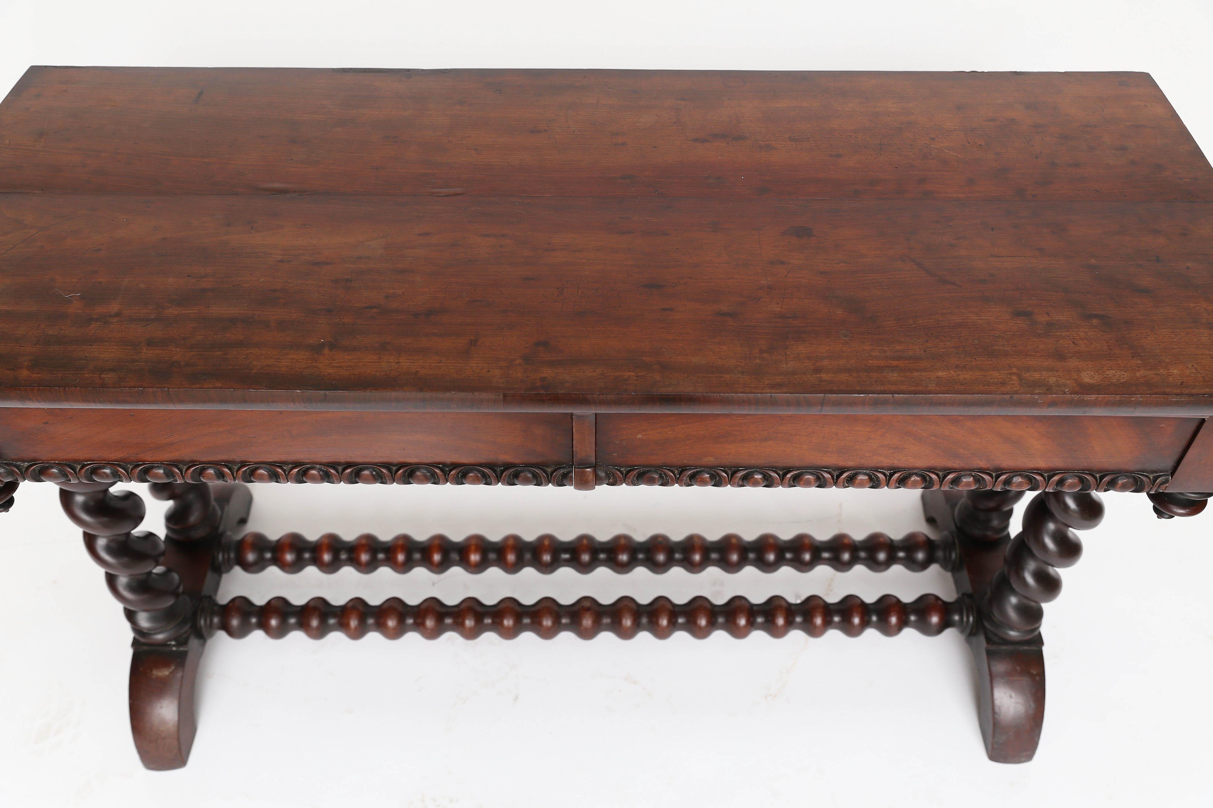 Beautiful 19th century barley twist console table found in England. The carved two drawers on the front are almost hidden as they blend with the construction of the table. The piece stands on four hand-turned barley twist legs joined by two barley