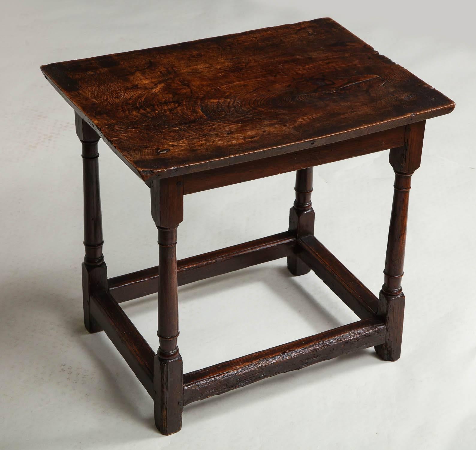 Fine English late 17th-early 18th century low table, the single ash plank top with vivid graining and having slightly undercut chamfered edge, over balustrade turned legs joined by box stretchers, the whole with exceptional color and patination to