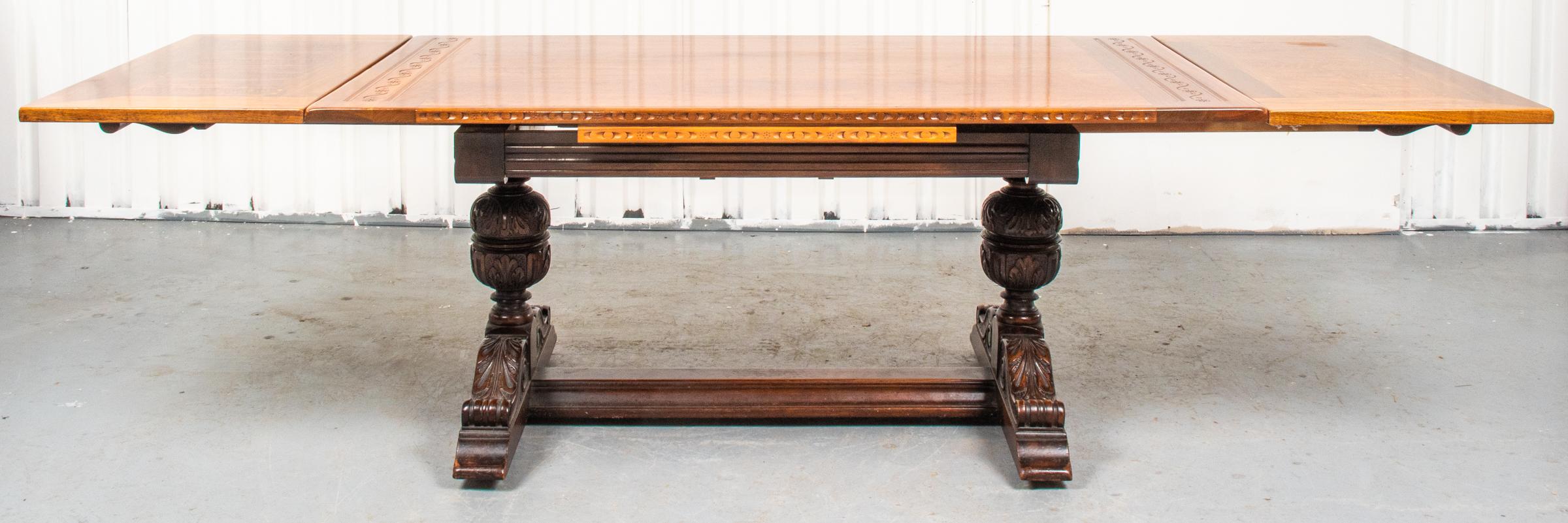 Extension mixed wood dining / trestle table, carved and inlaid in the English Baroque taste, the removable top rests on the two side retractable leaves, raised on bulbous cup and cover legs over acanthus carved feet. 30.5