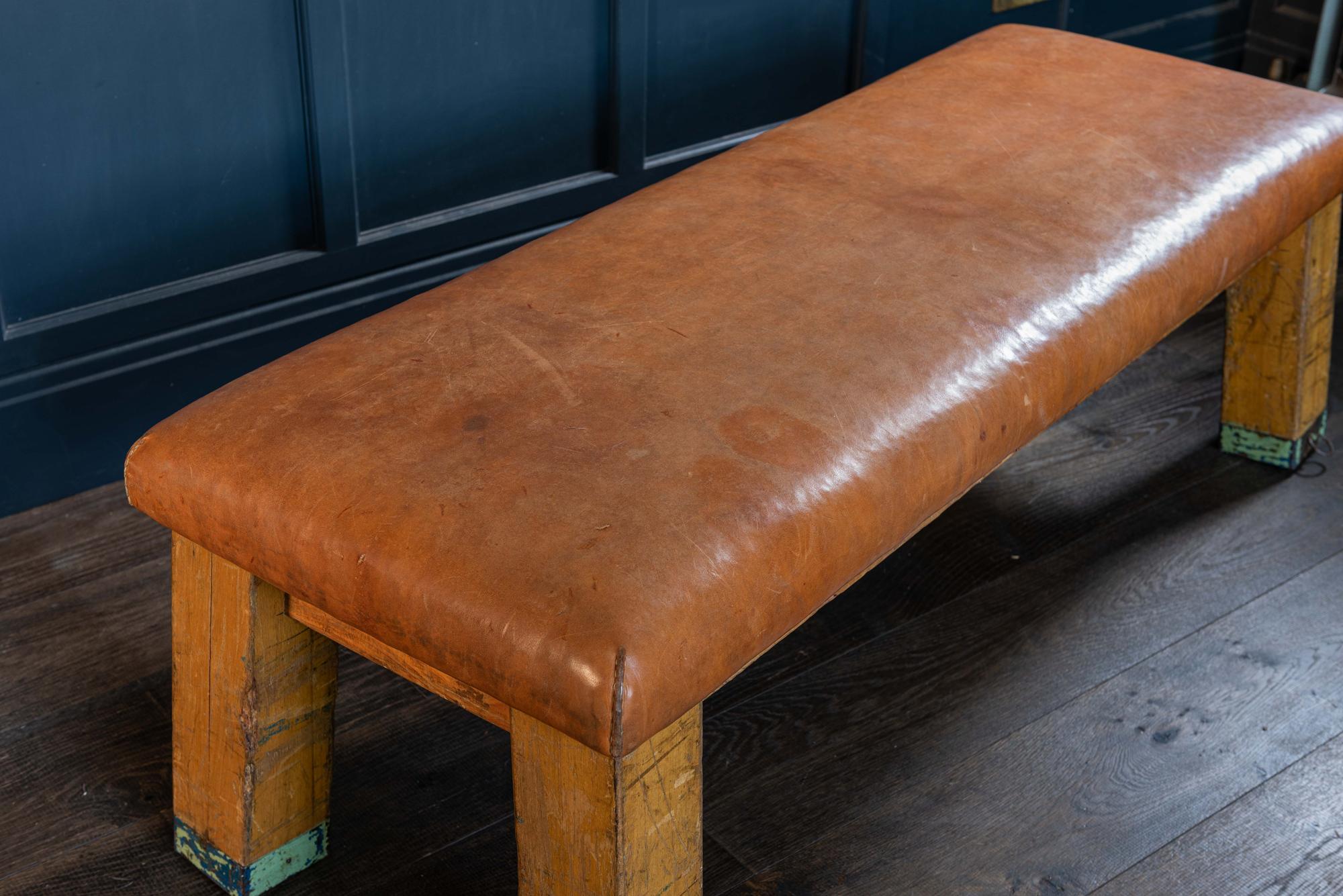 English beech vaulting bench/coffee table in cognac leather, early 20th century.
A versatile robust piece of furniture that can be used as seating, for dining or as a coffee table.
Each leg is capped with an iron strap and hoop.

Measures: W