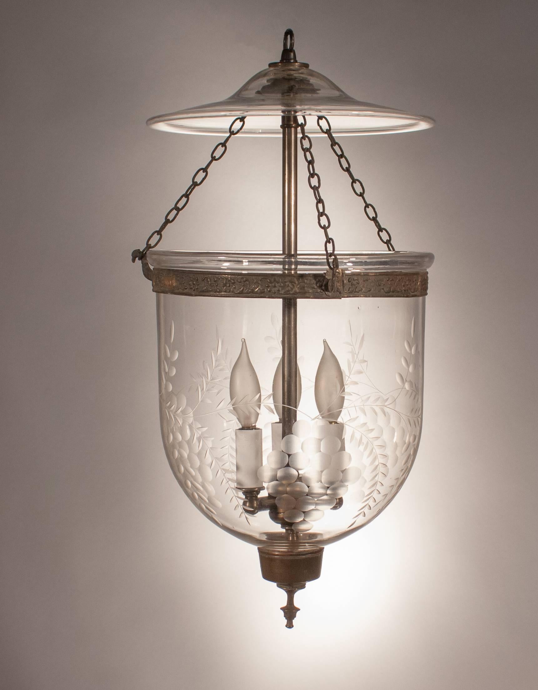 A lovely 19th century English handblown glass bell jar lantern with an etched grape motif. This circa 1860 hall lantern has beautiful form and all-original fittings—including its glass smoke bell, brass candle holder finial, and brass band with