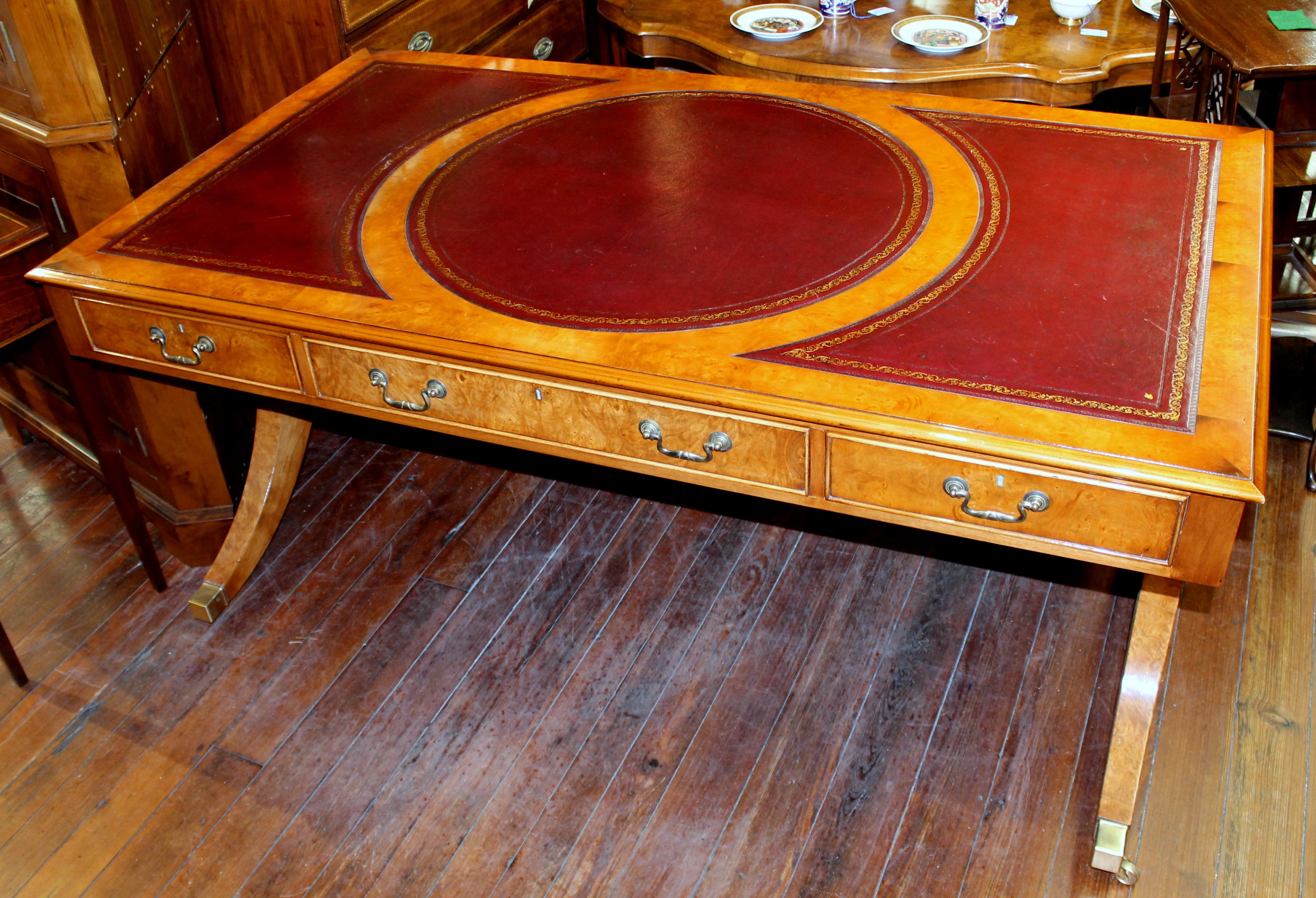 Fabulous quality reproduction English bench made burr elm regency style partner's bureau plat writing table made by our own UK proprietary staff.
Antique copy
With gilt and hand tooled burgundy leather writing surface. Burr elm veneers gleaned
