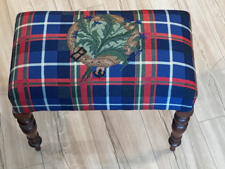 A small 19th c. foot stool or bench with colorful custom-done needlepoint upholstery, resting on four turned mahogany legs.