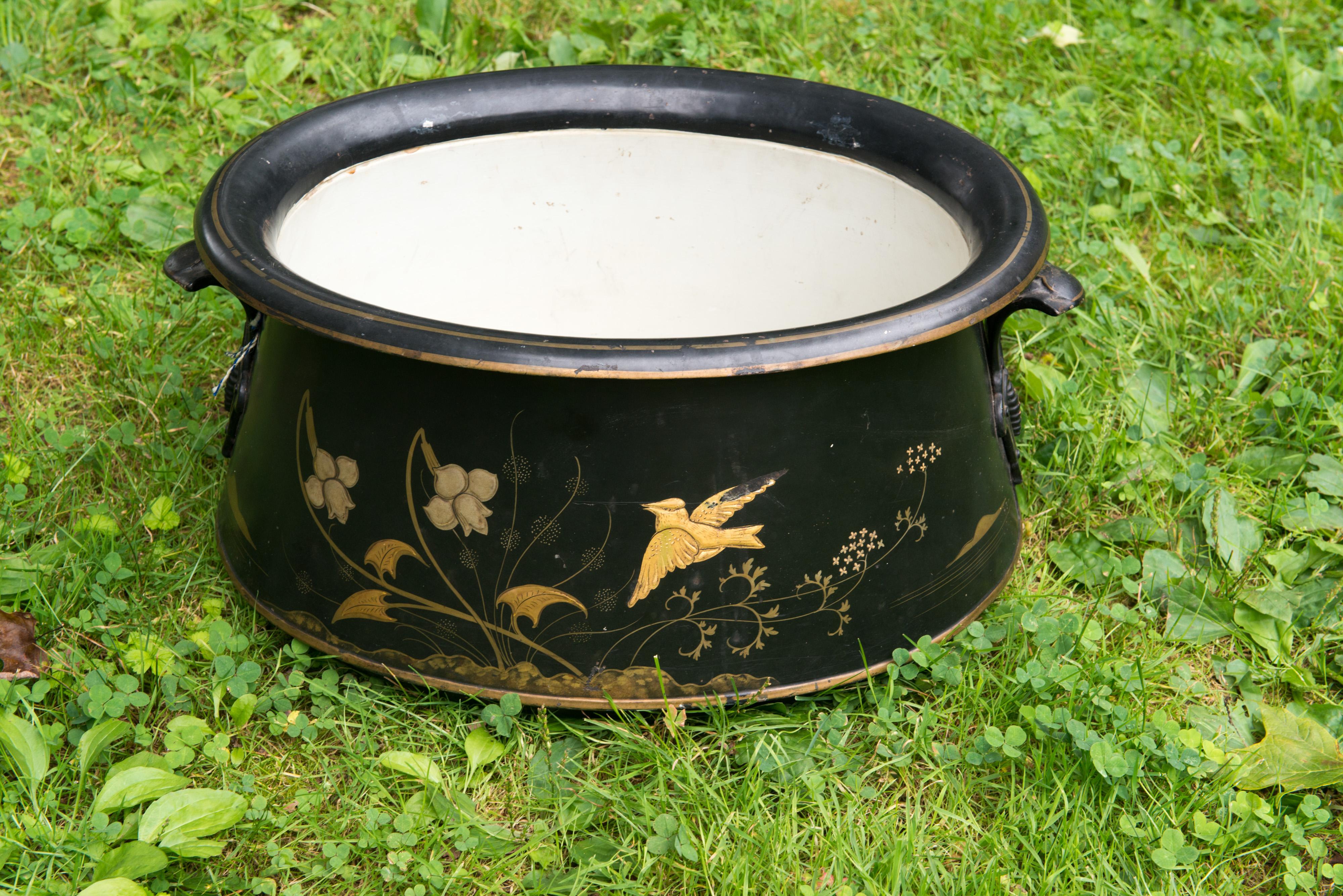 Late Victorian, Eastlake style large black tole planter with gold bird and flower designs.
Signed: Henry Loveridge & Co. Merridale Works Wolverhampton 04988 
Round metal medallion: Clifton