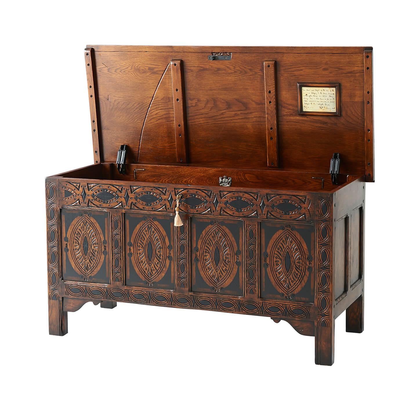 Cassapanca per coperte in quercia in stile inglese, il piano con bordo modellato, sopra lo schienale e i fianchi pannellati, la parte anteriore intagliata con ovali e losanghe su sostegni a stile con pennacchi a ogiva. L'originale inglese, circa