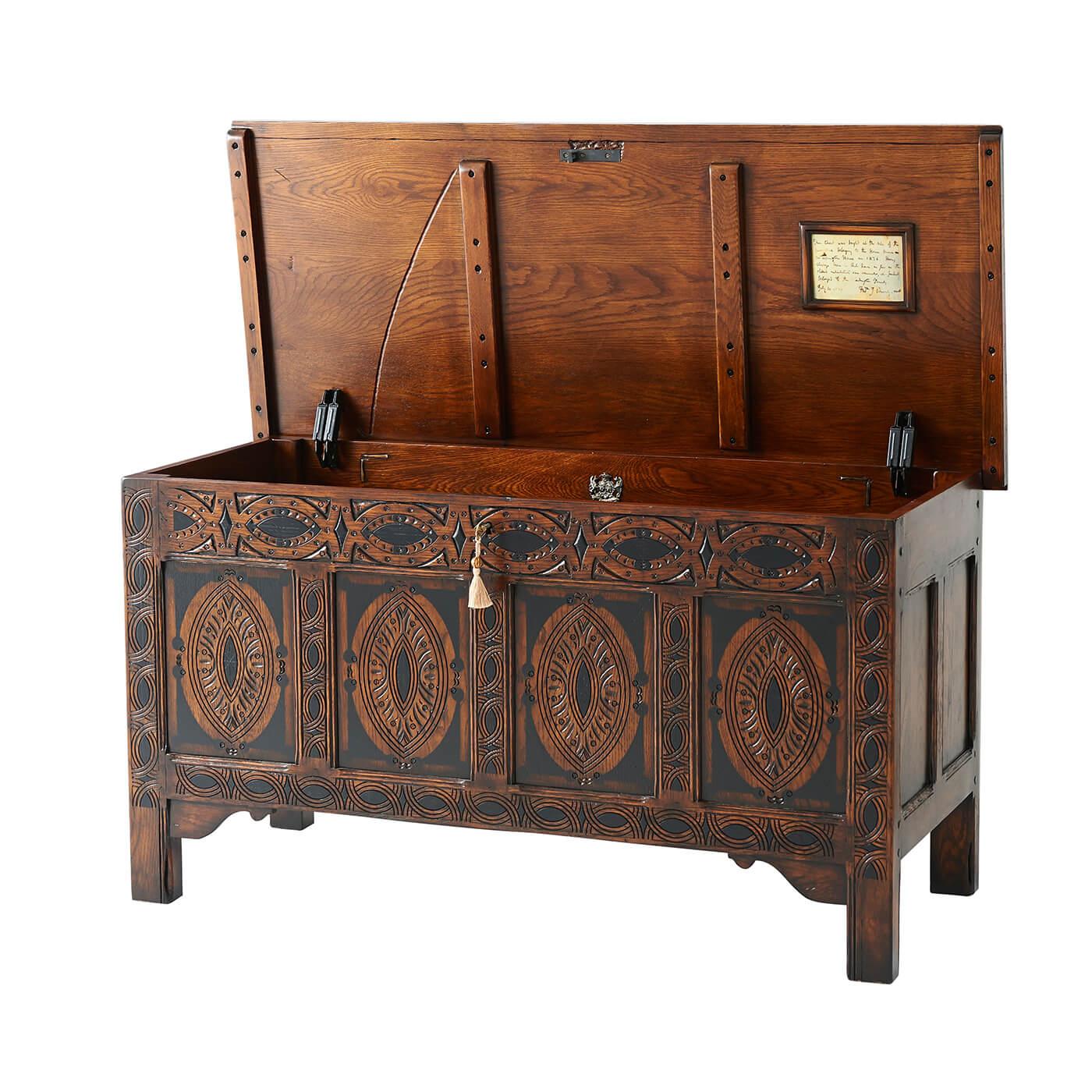 An early English style oak blanket chest, the moulded edge top, above a panelled back and sides, the front carved with ovals and lozenges on stile supports with ogee spandrels. The original English, circa 1650.

Dimensions: 53