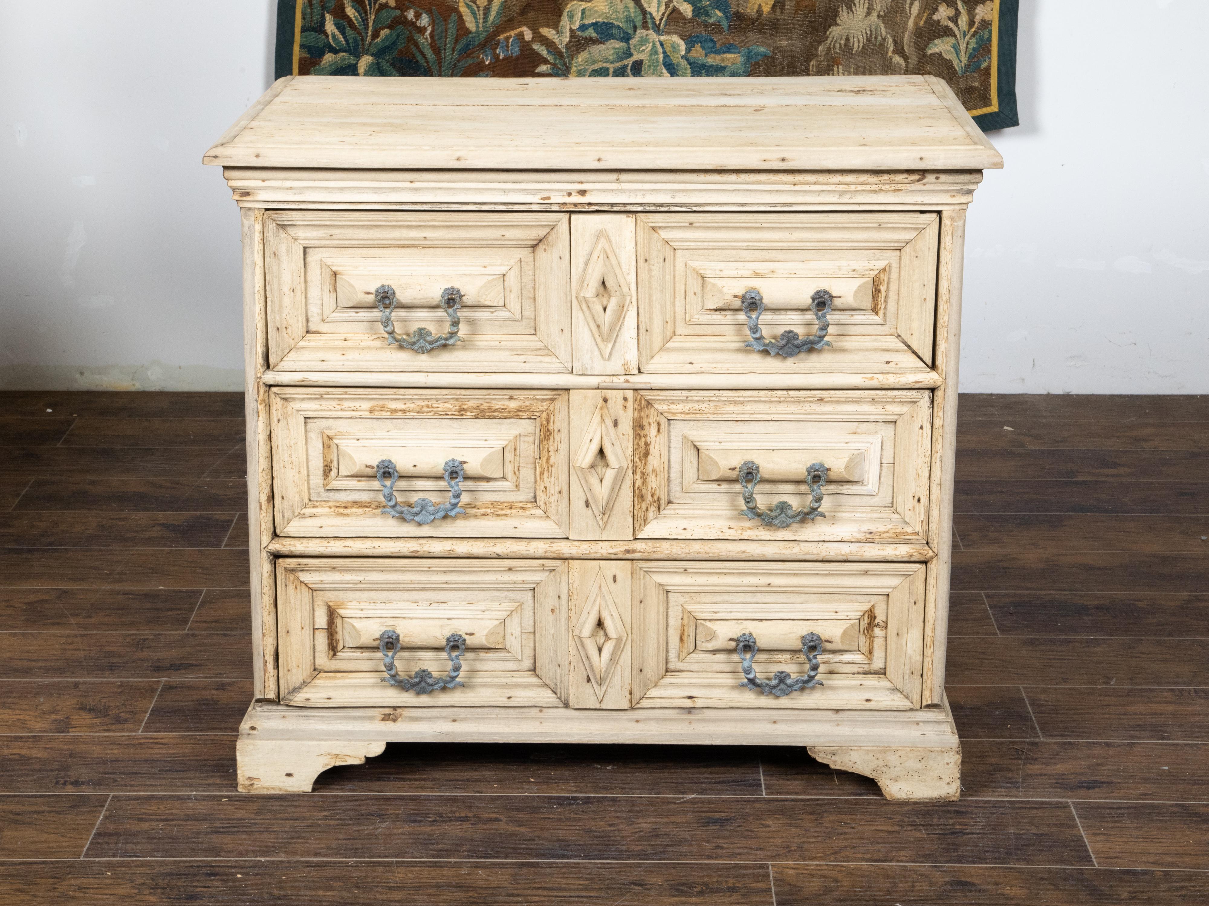 An English bleached oak geometric front chest from the 19th century with three drawers, carved diamond motifs, ornate hardware and great rustic character. Created in England during the 19th century, this bleached oak chest features a rectangular