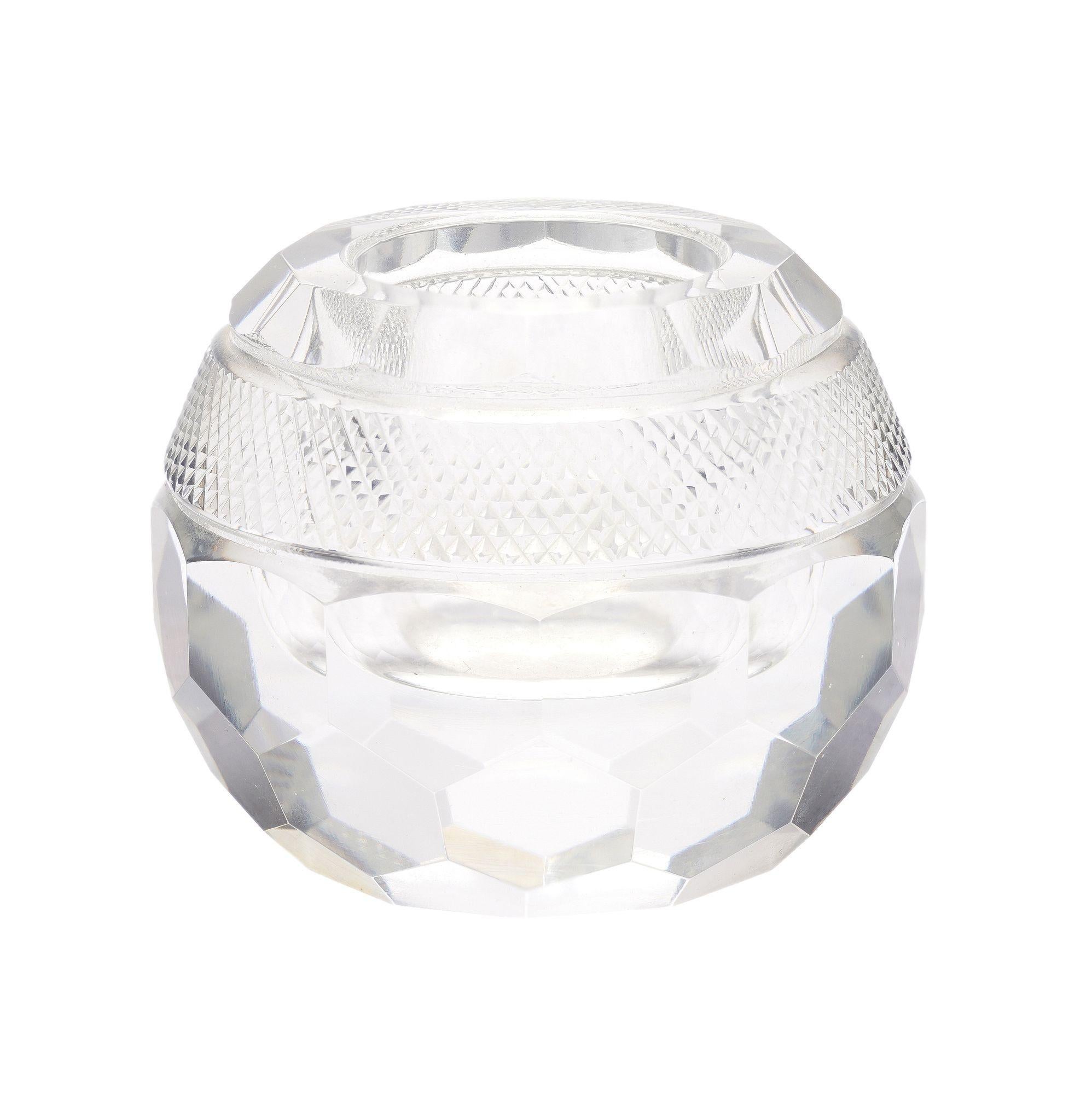 Globe form cut glass match strike. The lower half of the globe is slice cut in a beehive hexagonal pattern. Above the cut glass is a band of strawberry point for striking matches, and the top features an open well for storing matches.
England, late