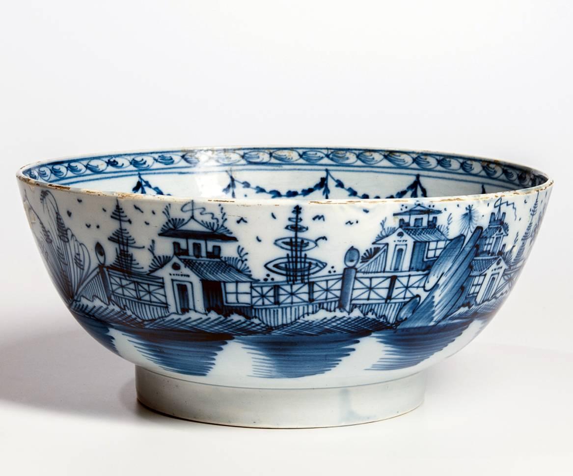 English blue and white pearlware pottery chinoiserie bowl, 
circa 1790-1800

The underglaze blue bowl fully decorated with Chinoiserie scenes of Chinese building encircling the exterior of the bowl. The interior fully painted with a garden scene