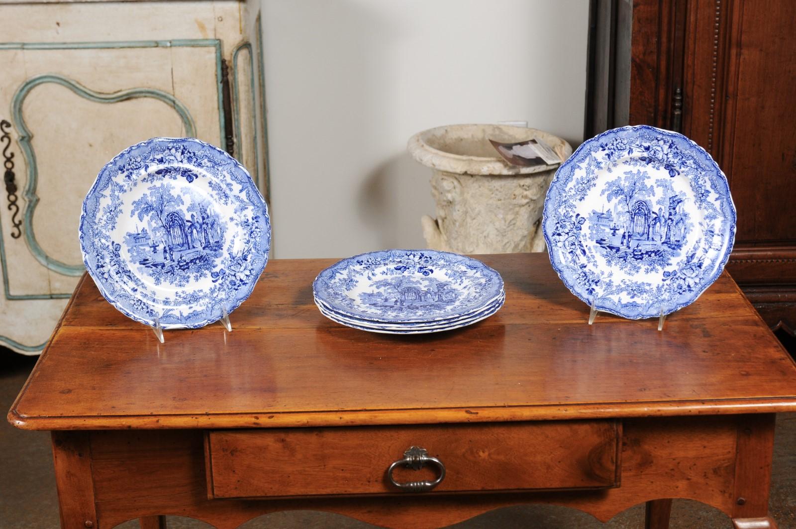 Six English blue and white transferware dinner plates from the 19th century, with Gothic ruins motifs, sold individually. Born in England during the 19th century, each of these six blue and white dinner plates is adorned with a romantic décor