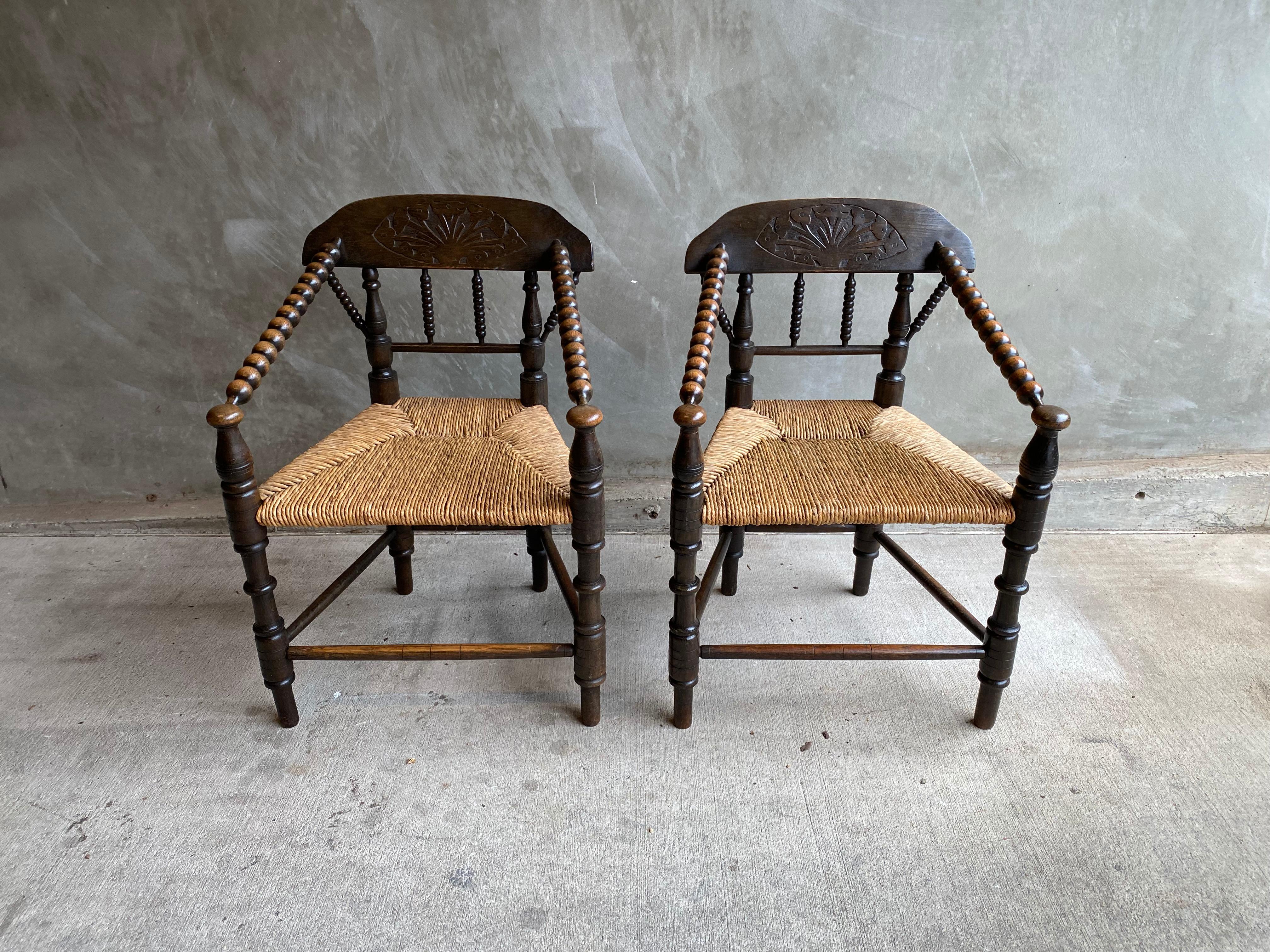 Pair of chairs in English bobbin style with rush seats and dark stain over oak. Matching settee also available. See listing LU1140228508482 for matching 19th century bobbin settee.