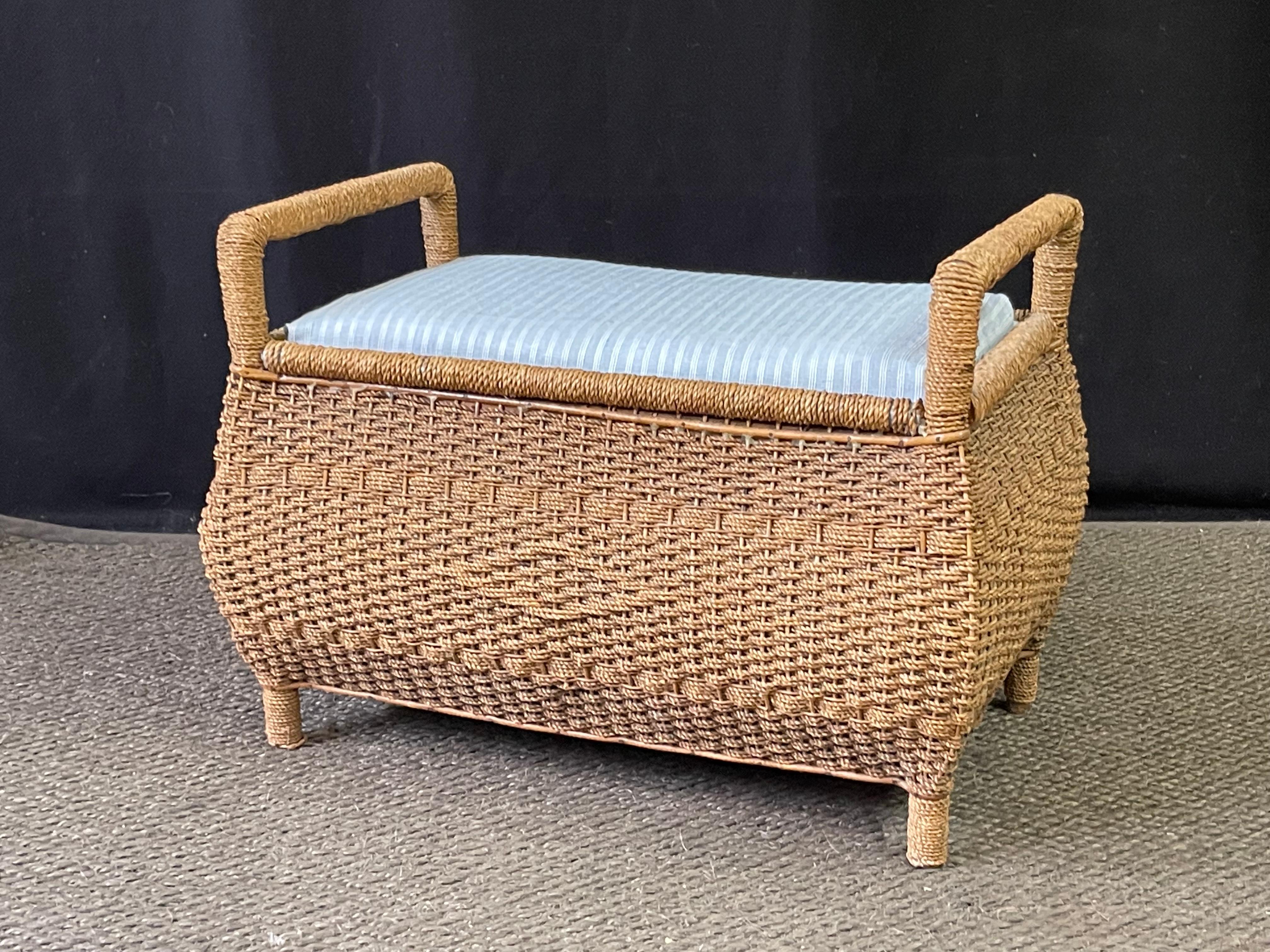 20th Century English bombay-shaped bench of rattan with ornate diamond and stripe decoration woven into the front. Beneath the upholstered seat cushion is a generous storage cavity originally used for sewing/looming supplies. The bench can be easily