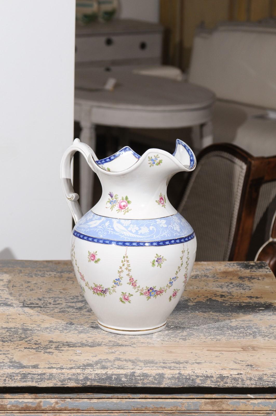 An English Booth's silicon China cameo pattern pitcher from the early 20th century, with pink roses and blue and white pheasants. Born in England during the early years of the 20th century, this exquisite pitcher features a lovely decor made of