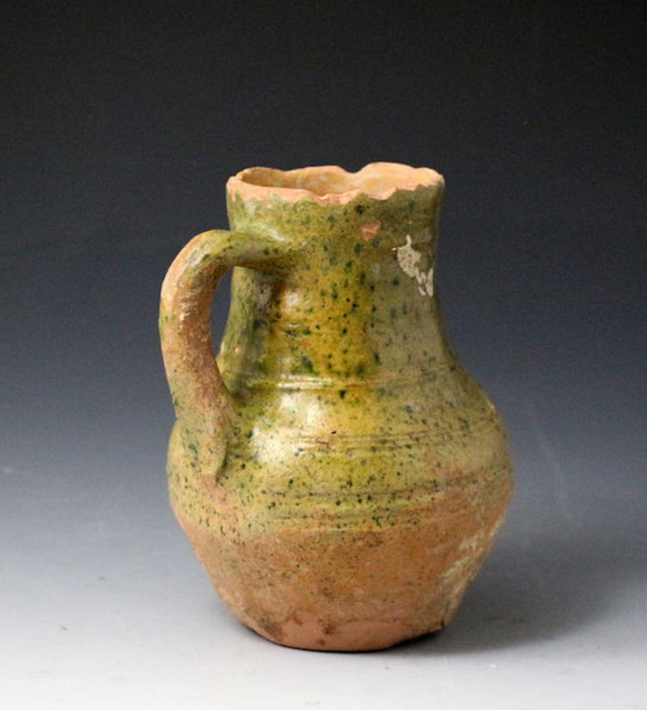 Dated: 1575 to 1600 Surrey Hampshire, England

Border ware pottery pitcher with ribbed decoration with a good well executed copper-lead glaze 
excavated in Putney London in 1972. 
Note; 
Border ware 
Surrey-Hampshire Border ware ceramics