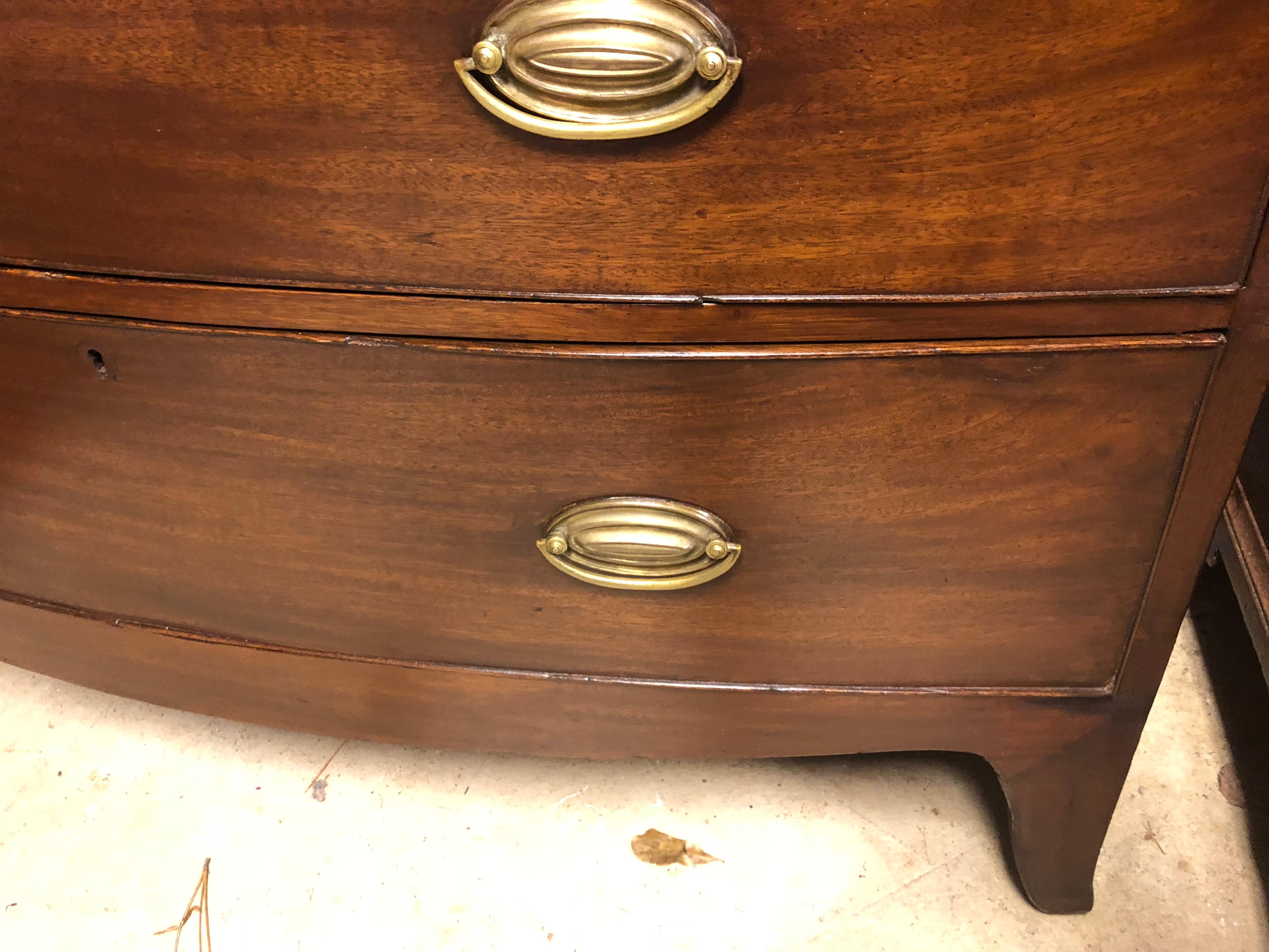 English bow front chest, circa 1830, inlaid round dark wood escutcheons, nice skirt and feet, oak interiors, replacement solid brass ovals, drawers work well, tall and not too deep. A traditional bow front chest in medium to dark mahogany.