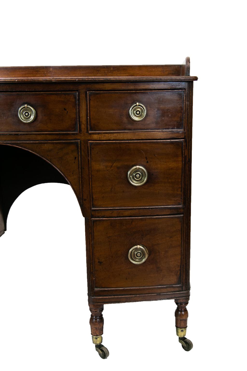 This English bow front server has a molded edge gallery on top as well as molded edges on the bow front and sides. The corners on either side of the outside banks of drawers are flanked by reeded quarter columns. Below the center drawer is a
