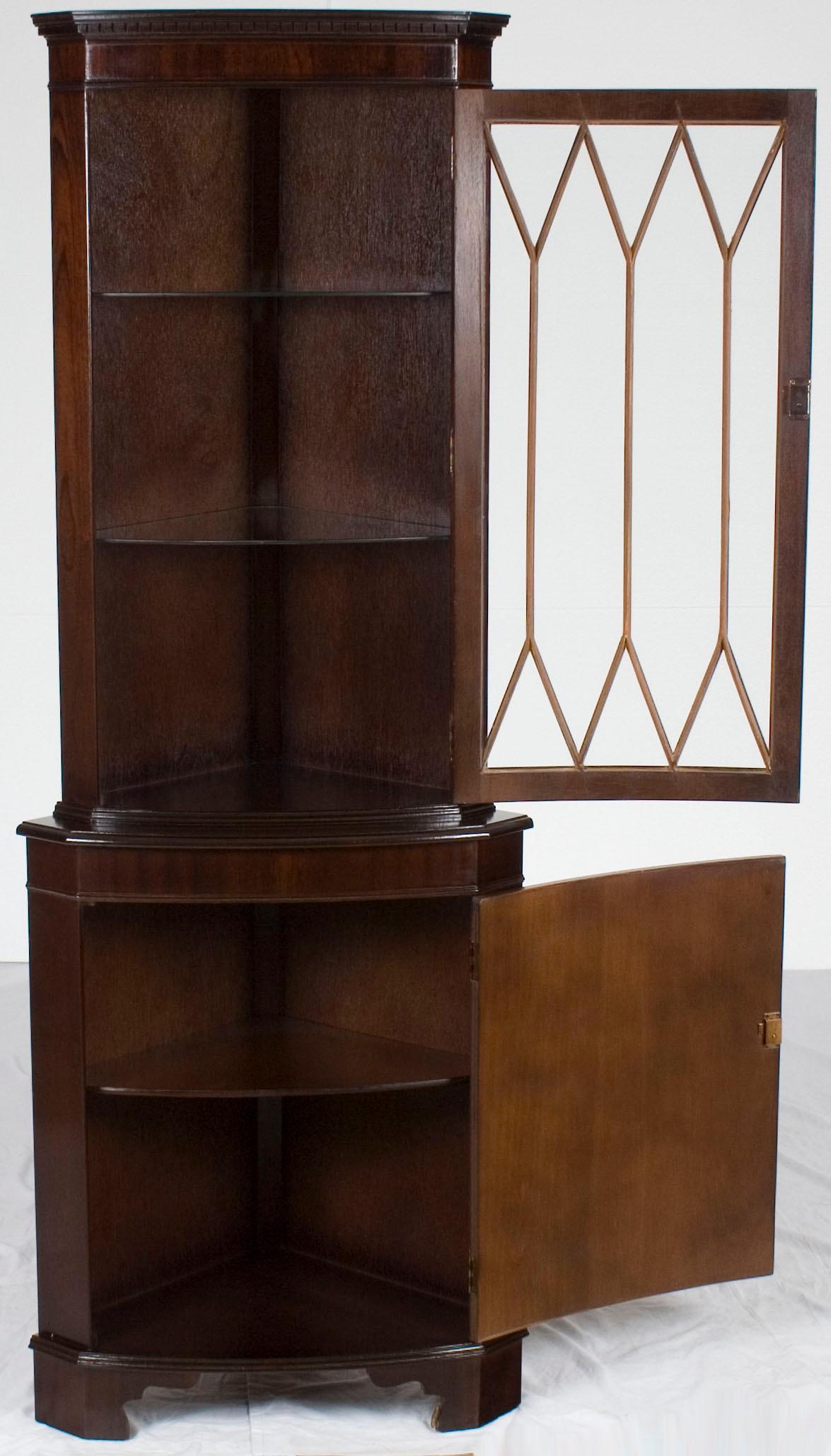 Crafted around the year 1960, this antique mahogany corner cabinet is an exemplary piece of quality English craftsmanship. Featuring flame mahogany wood, individually paned glass, and locking doors, it remains in good condition.

Cabinets like