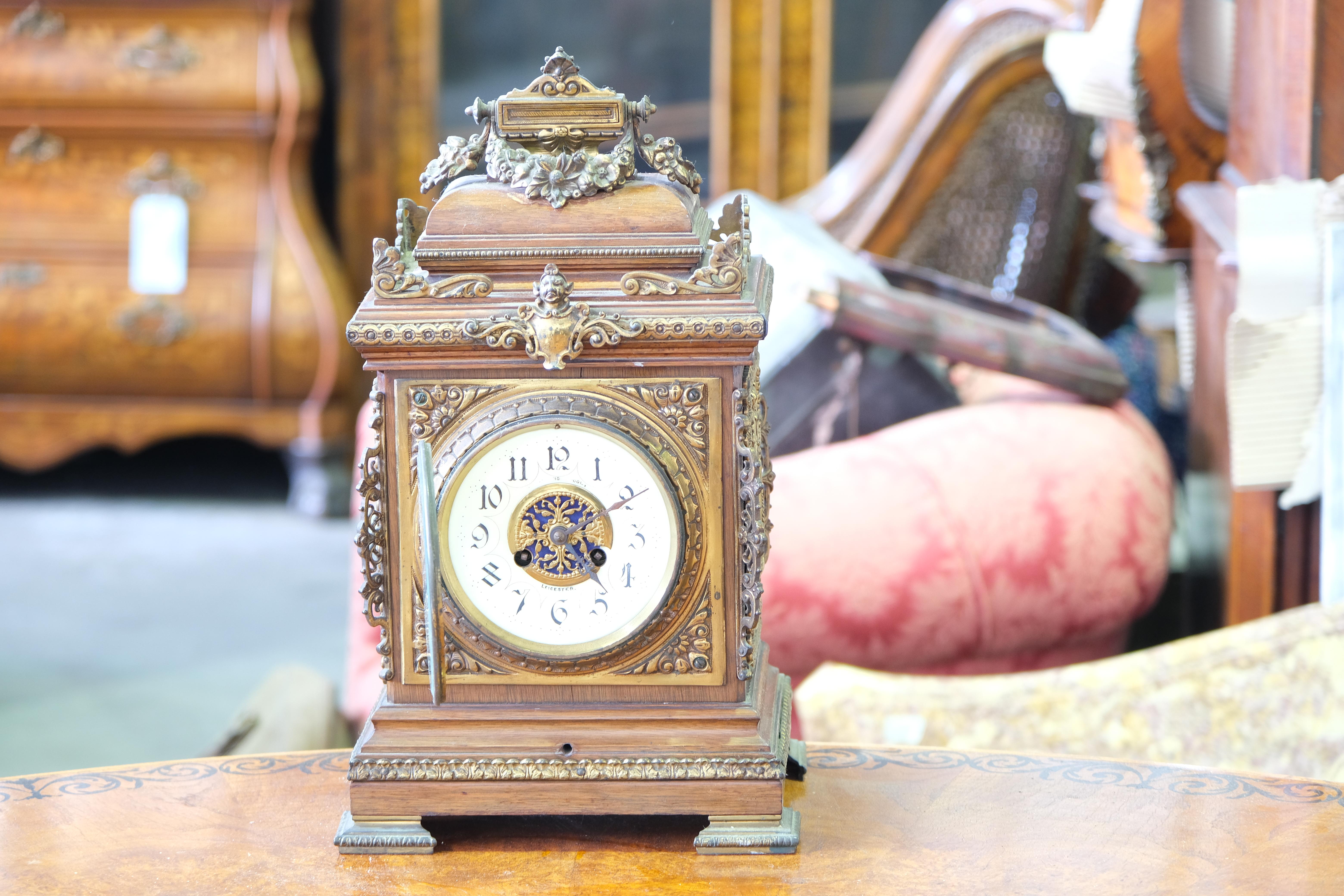 A fine quality 19th century English bracket clock of the Georgian era. The classical styled numerals and gilt topped case are surmounted by a floral sculpture. Marked on the face 'Leicester'. 