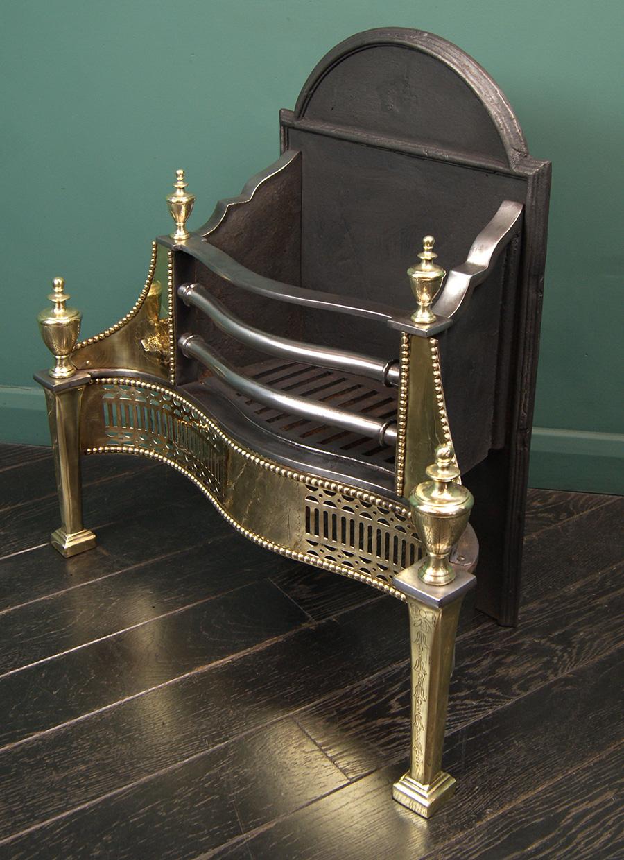 Grille à chien de style Adams en laiton anglais poli de Jordan, Son & Prior avec une frette cannelée et percée, des pieds effilés surmontés de fleurons en forme d'urne. Gravure fine sur la frette centrale, les ailes et les pattes. Une réplique du