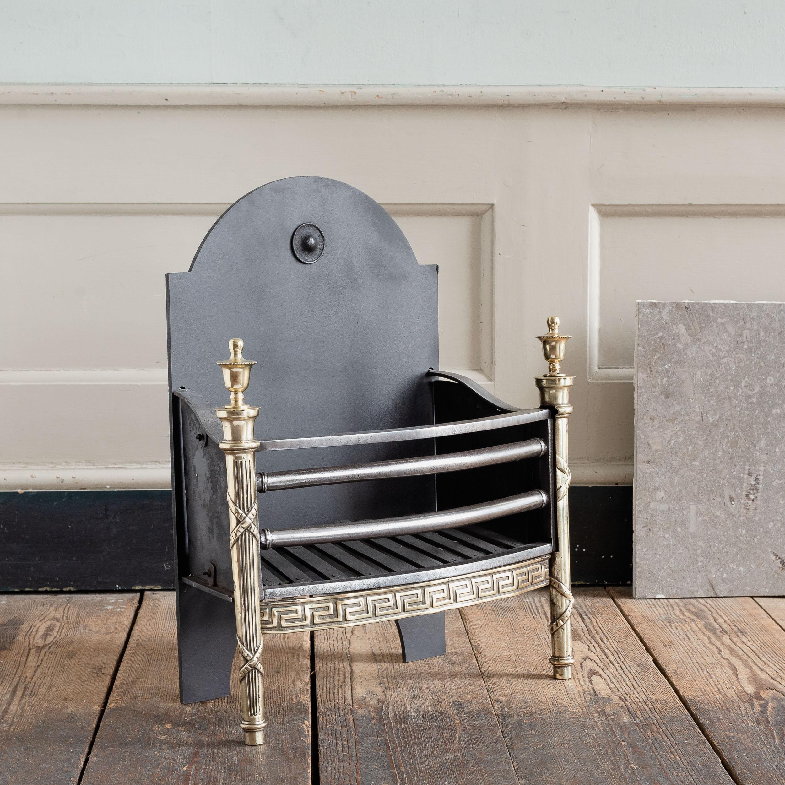 An English brass and steel fire basket, mid-twentieth century in the Regency style,
with urn-topped tapered standards and Greek-key apron. A smart and stylish fire grate with well-cast decorative elements, restored, repolished and ready for