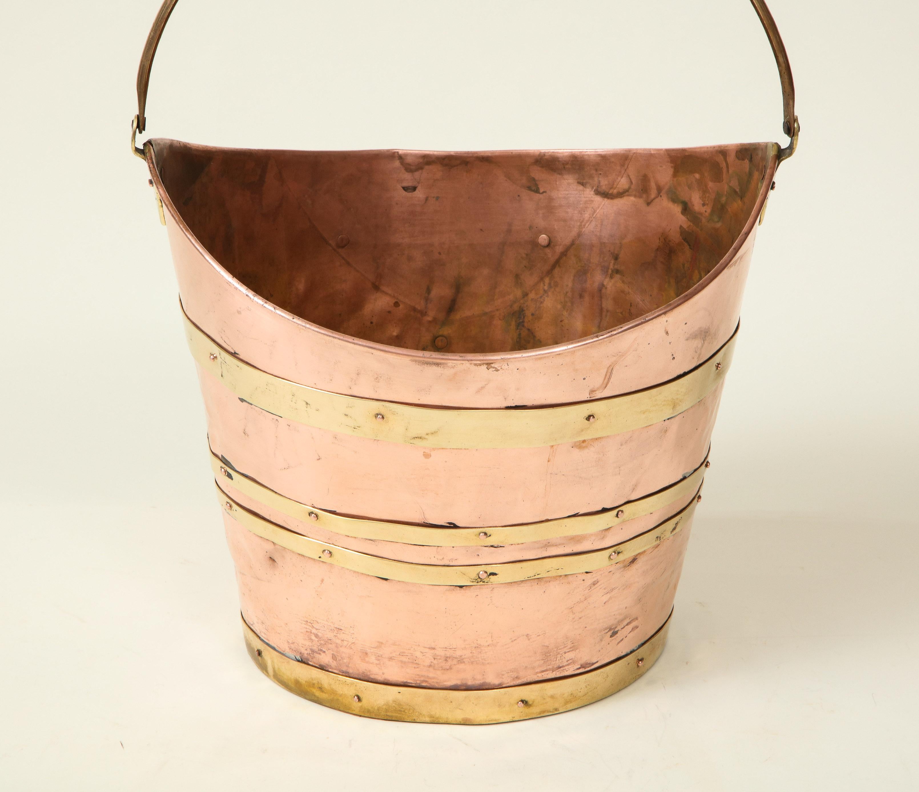 Wide-mouthed bucket mounted with brass straps. Underside stamped 