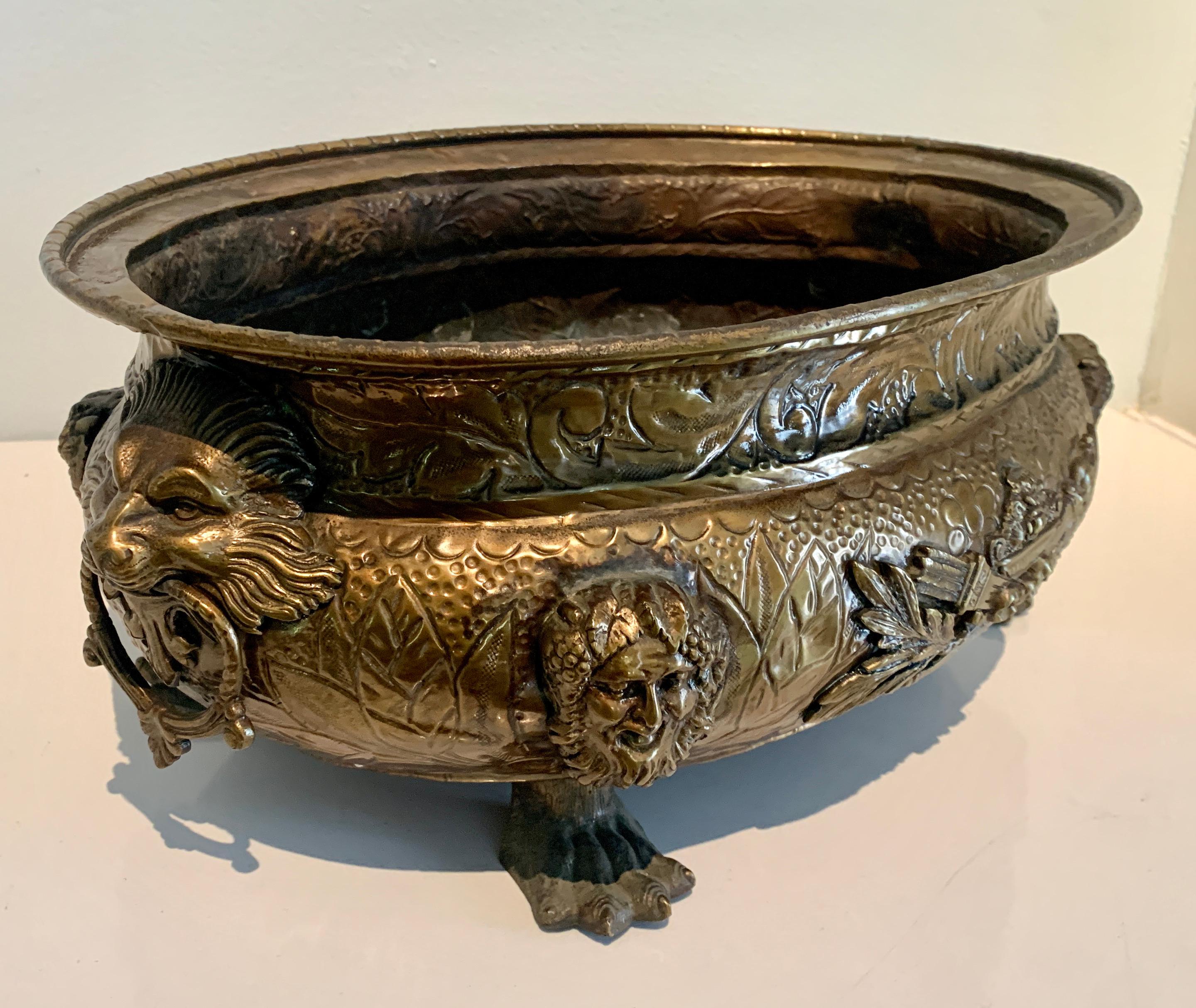 English brass footed coal bin jardiniere with lions heads, rings and paw feet details - a wonderful brass Jardiniere, the large, deep and oval design make this a compliment to any outdoor garden area, as a centerpiece or to store kindling! circa
