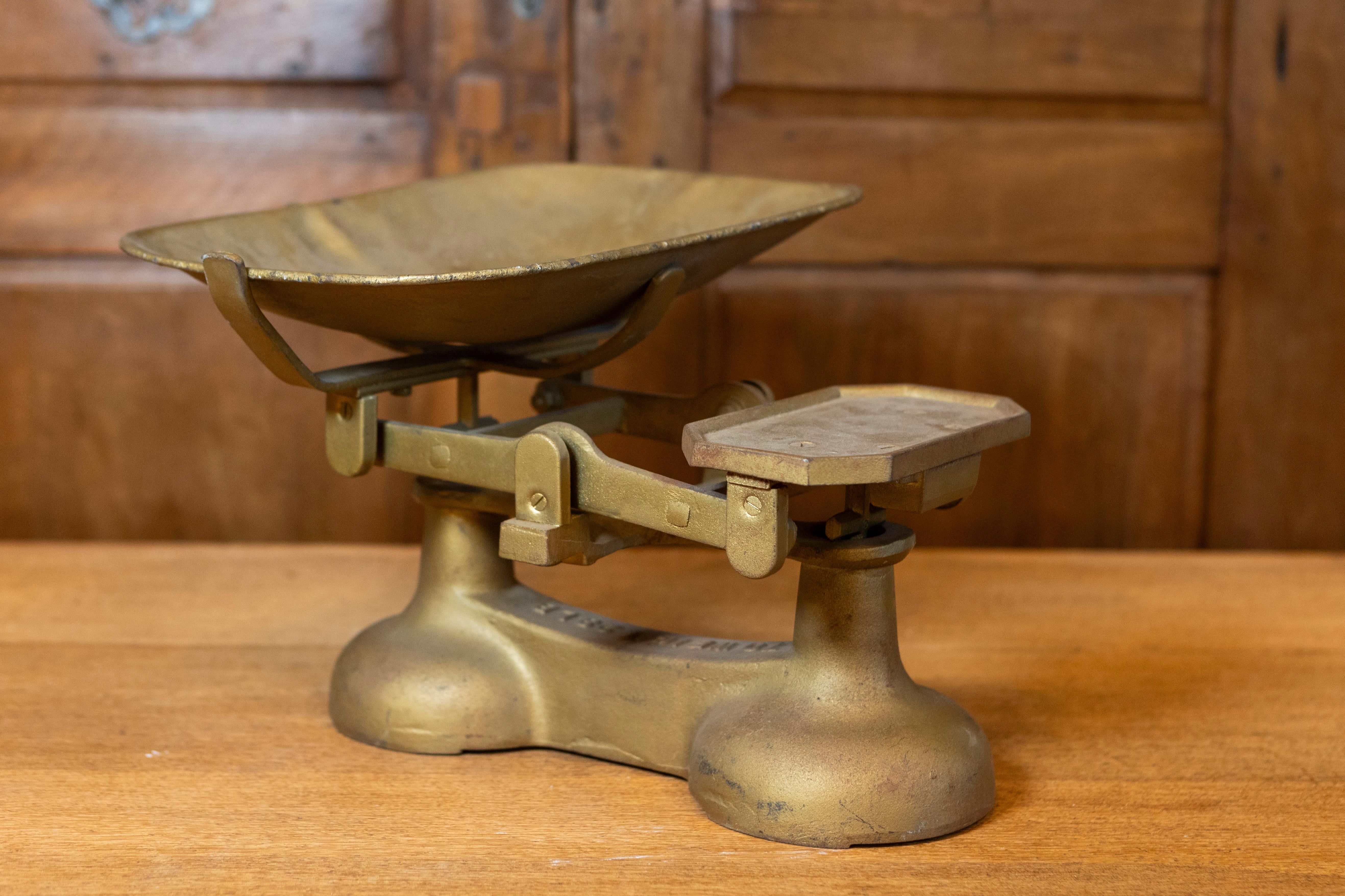 Balance anglaise en laiton du 20e siècle, pouvant peser jusqu'à 28 livres. Cette balance anglaise en laiton du XXe siècle est un exemple frappant de fonctionnalité et de charme vintage. Conçue pour peser jusqu'à 28 livres, cette balance était un