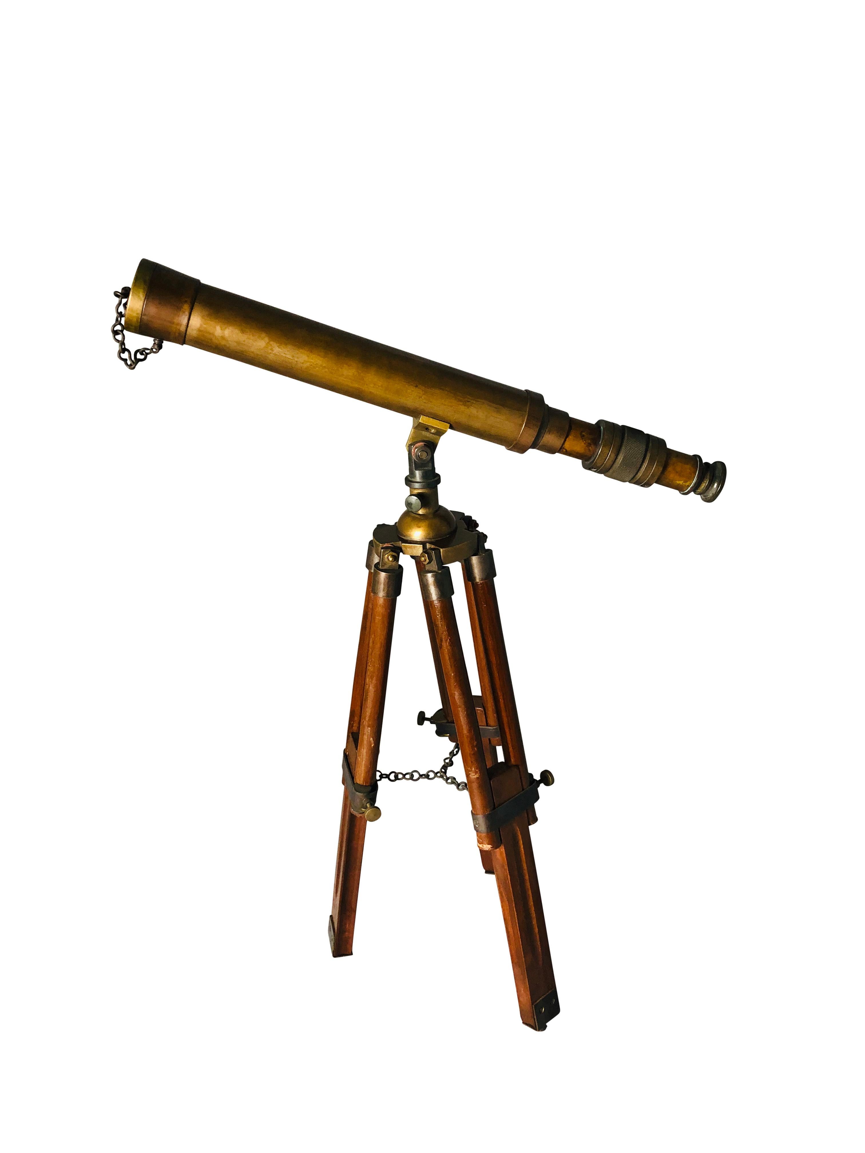 A beautiful 20th century English brass telescope on an adjustable mahogany tripod base. Offered in complete original condition. An amazing addition for a home.