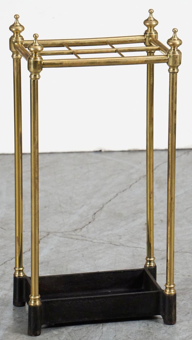 A fine English brass umbrella or stick stand for the hall or entryway from the Edwardian era, featuring tubular brass supports with finial tops and six sections over a heavy cast iron base.