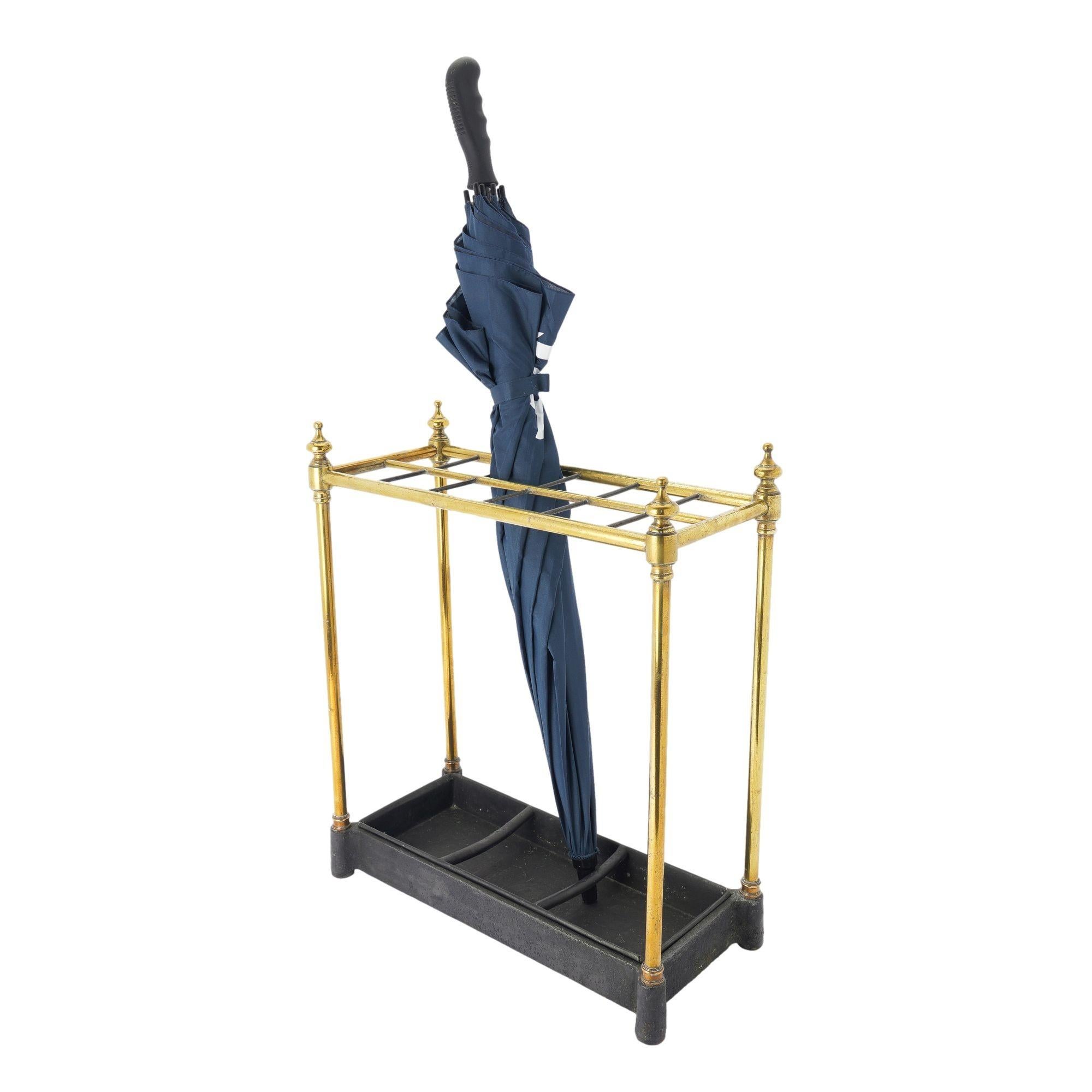 Generously sized rectangular umbrella stand in brass, cast iron, and sheet metal. The cast iron base features turreted corners for brass rod vertical supports, and the top frame is divided into 12 sections, providing ample room for umbrellas, canes,