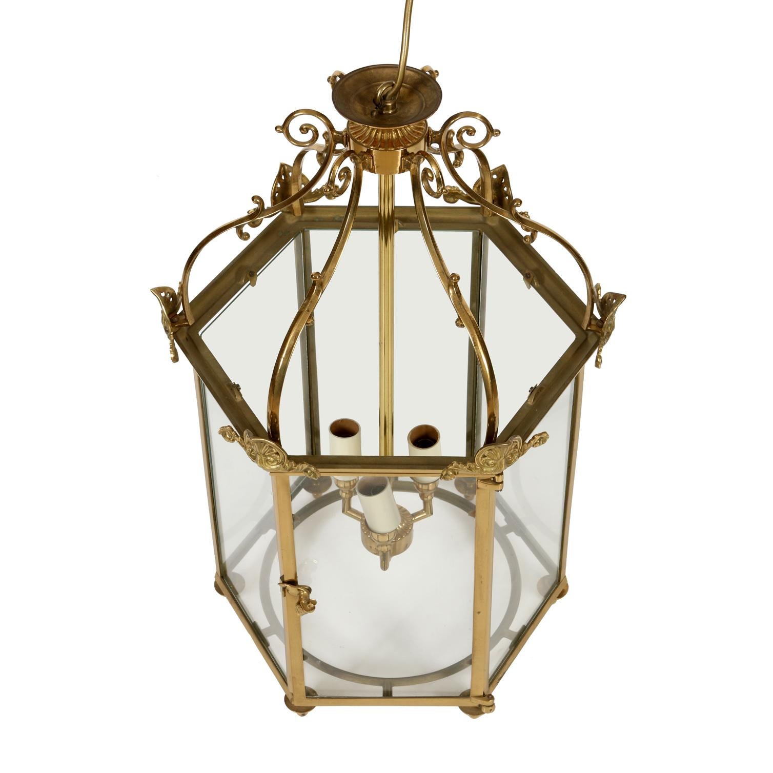 English brass vintage hall lantern in hexagonal shape with small palm details above and finials below with three lights.