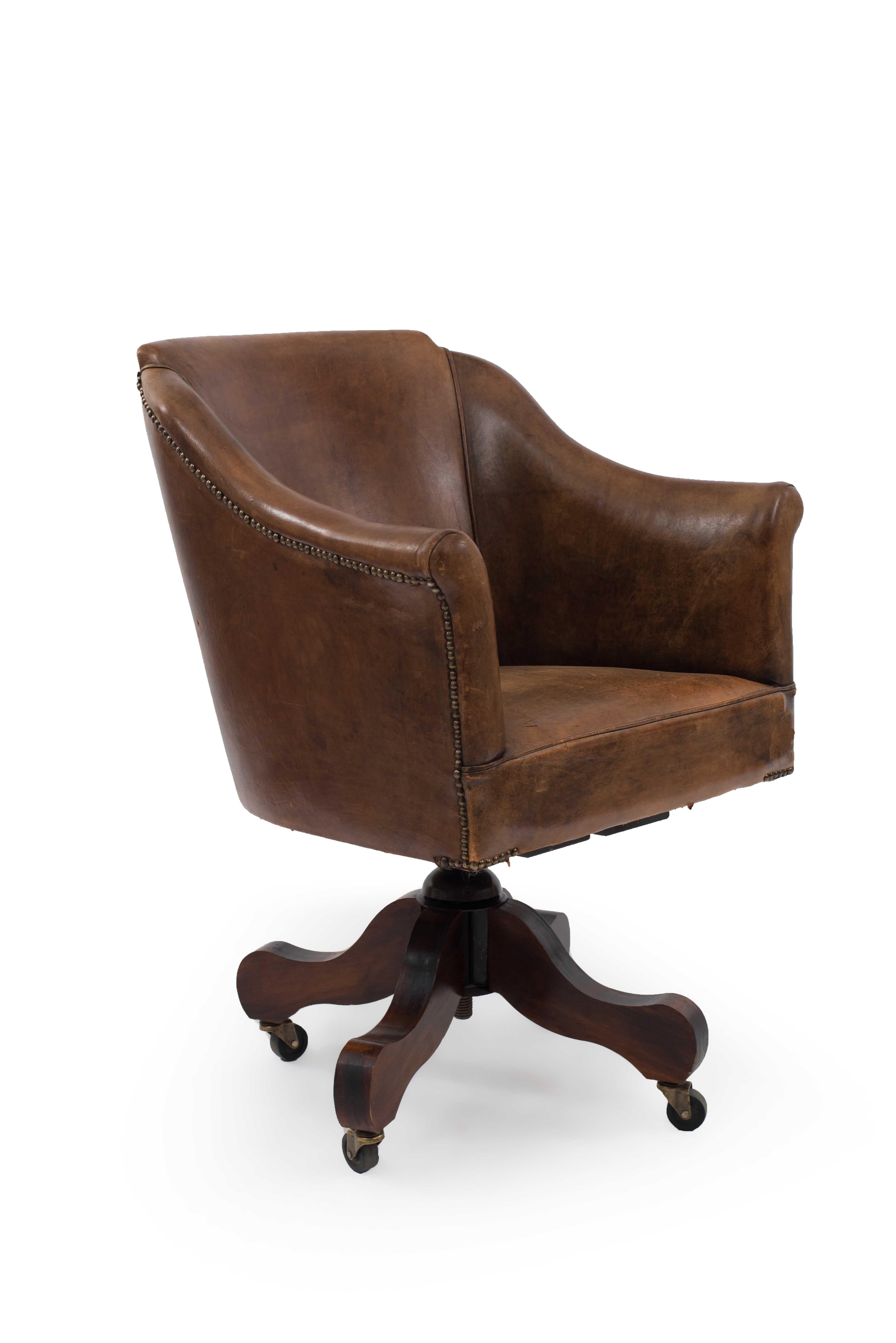 English style brown leather rounded and shaped back swivel chair with flair design arms and nail head trim.