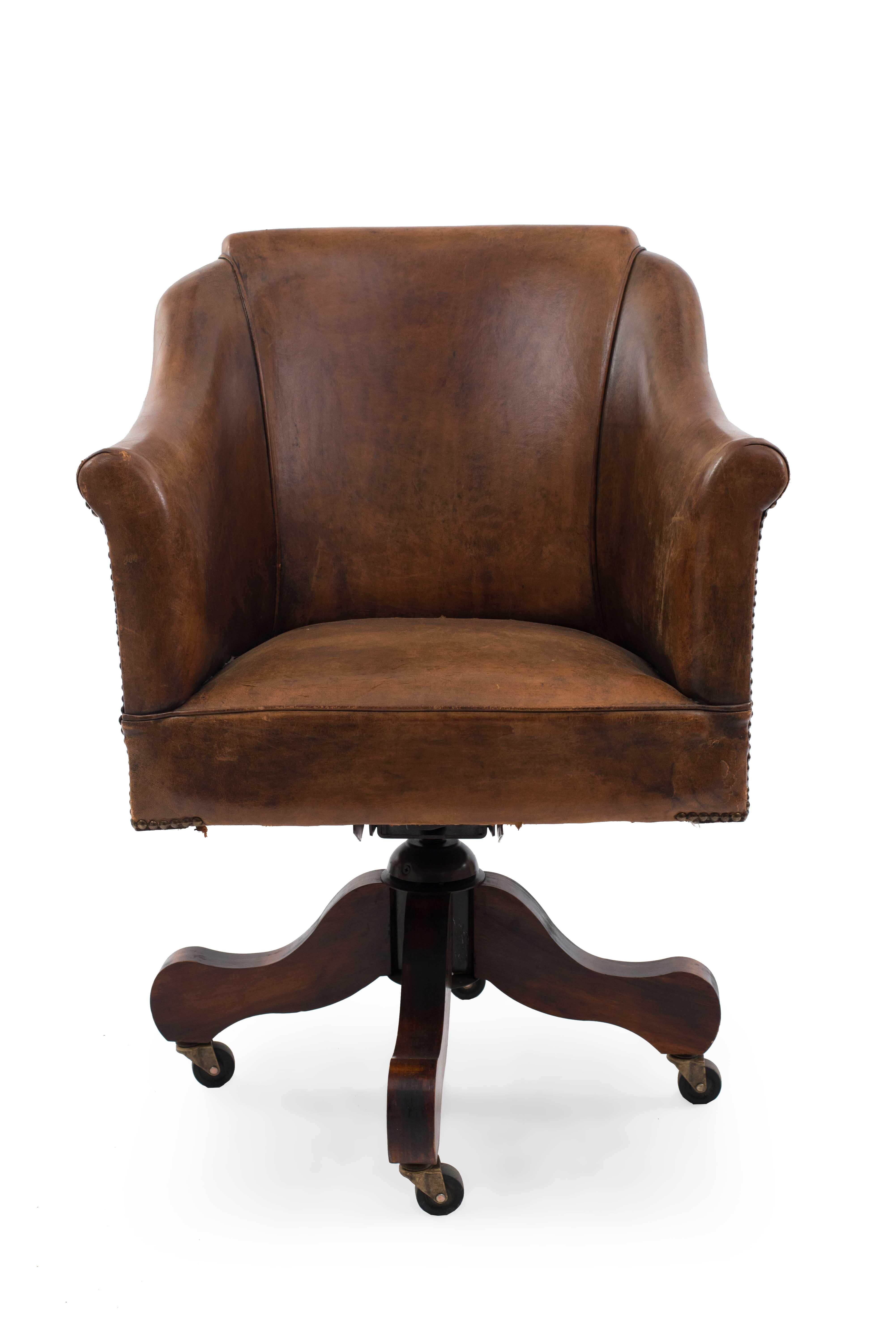 English style brown leather rounded and shaped back swivel chair with flair design arms and nail head trim.