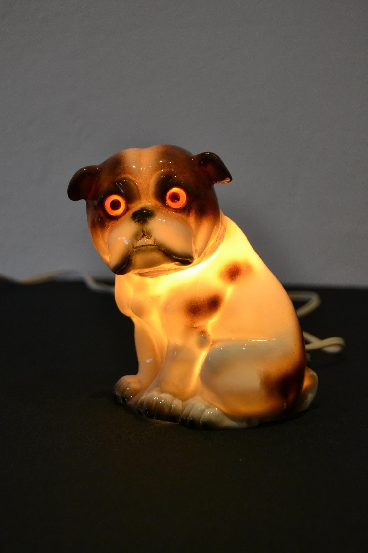 Englische Bulldogge Parfümlampe. 
Parfümlampe aus Porzellan in Form einer englischen Bulldogge. 
Er hat eine Schleife um den Hals, an der man die Löcher für das Parfümöl sehen kann. Mit der Wärme des Lichts wurde der angenehme Duft in den Raum