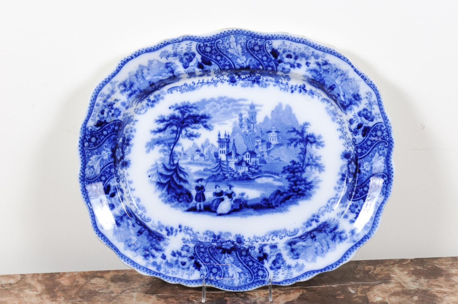 An English Burgess & Leigh Middleport Nonpareil pattern flow blue platter from the late 19th century, with outdoor scenery and scalloped edge. Born in the Middleport pottery during the late 19th, early 20th century and created by Burgess & Leigh,