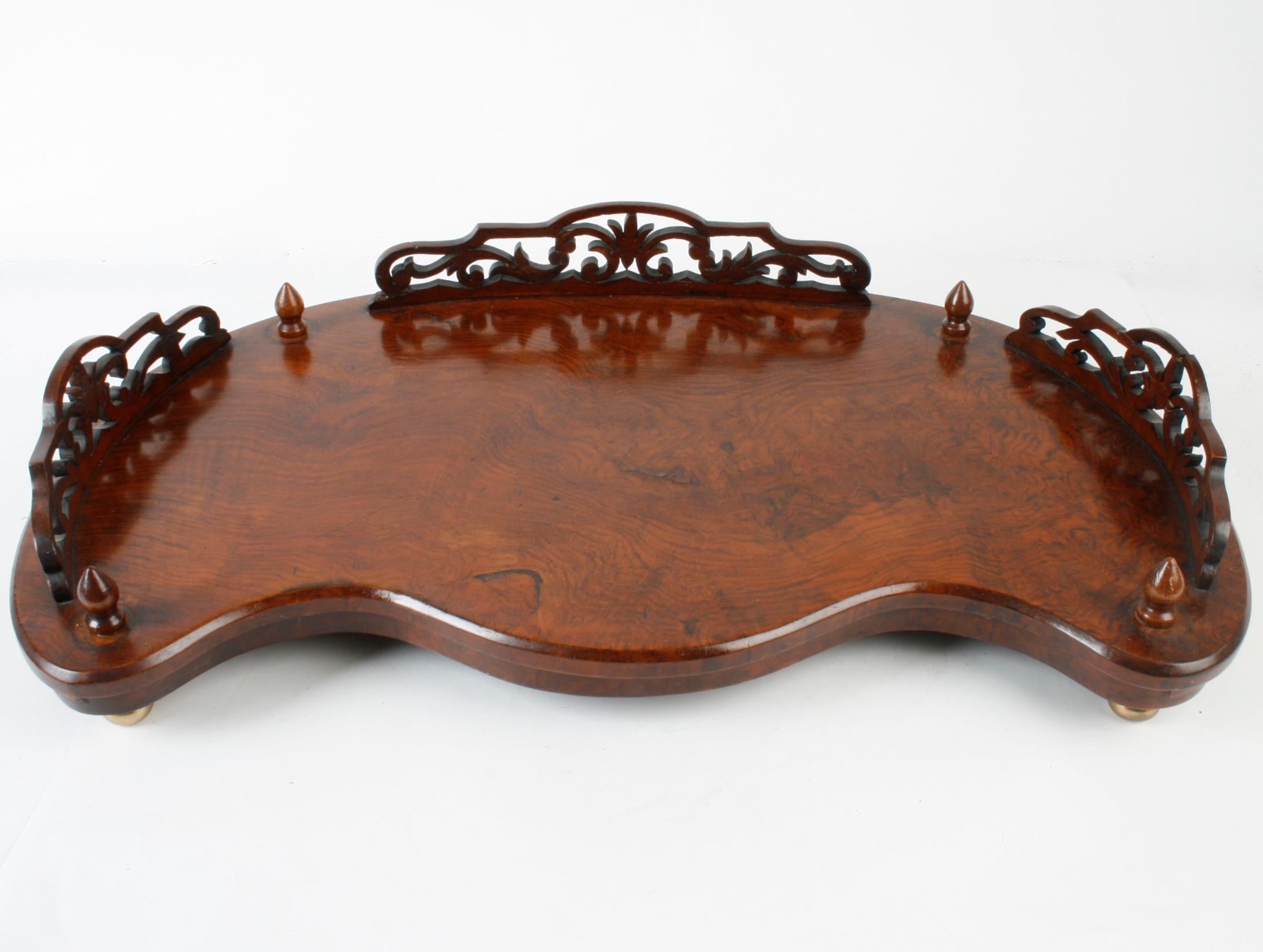 A Victorian rosewood dressing table tray with pierced gallery and brass ball feet, circa 1840. It has a beautiful kidney shape and wood finials.
N.P. Trent has been a respected name in antiques for over 30 years with a large collection of period