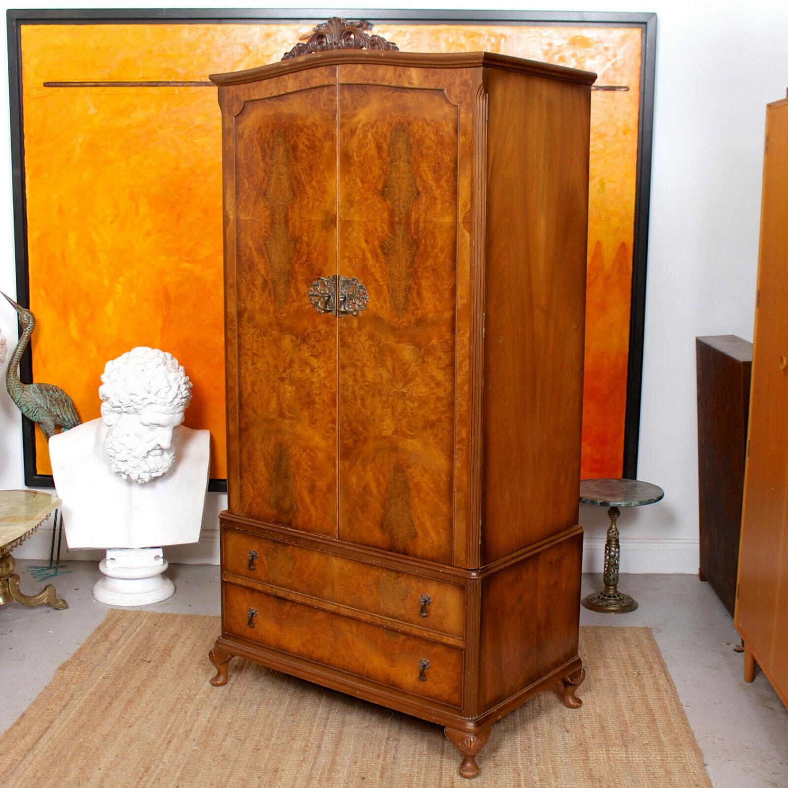 An impressive walnut wardrobe.
Well carved and pierced cresting above a pair of burl walnut marquetry doors with brass escutcheons enclosed a fitted interior comprising hanging rail, tie rack, glazed cupboards above two long drawers and raised on