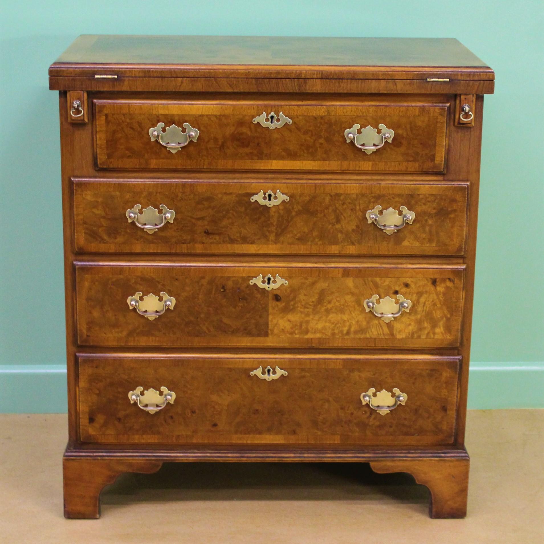 A charming George I style burr walnut bachelors chest of drawers. With a fold-over top (supported by pullout / pull-out loppers when open). With an arrangement of 4 graduated drawers, all fitted with their original solid brass swan-neck handles. The