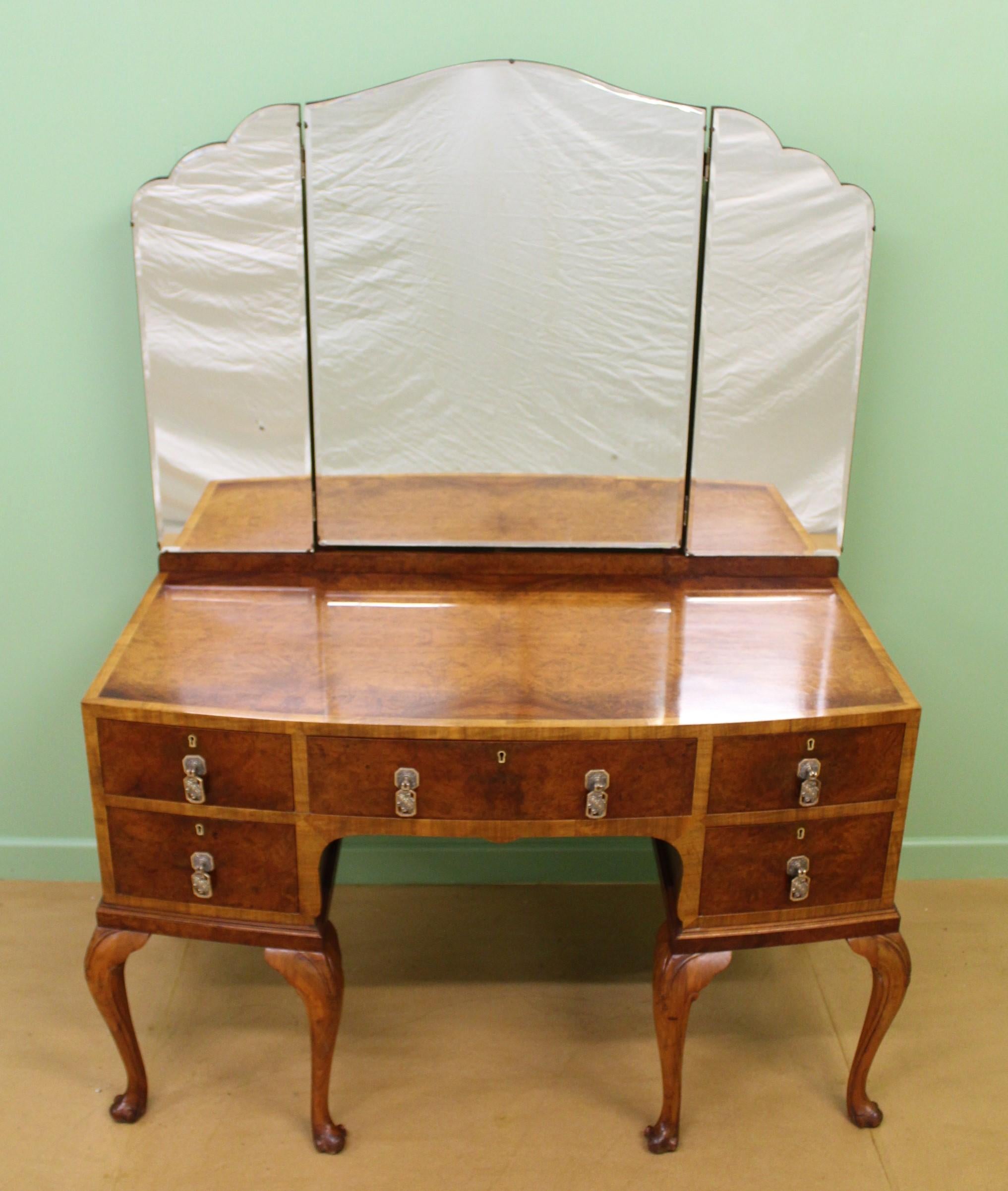 An excellent burr walnut Queen Anne style dressing table of generous proportions. Well constructed in solid walnut with attractive burr walnut veneers onto a solid mahogany carcas. The triple mirrors are fitted with their original beveled glass