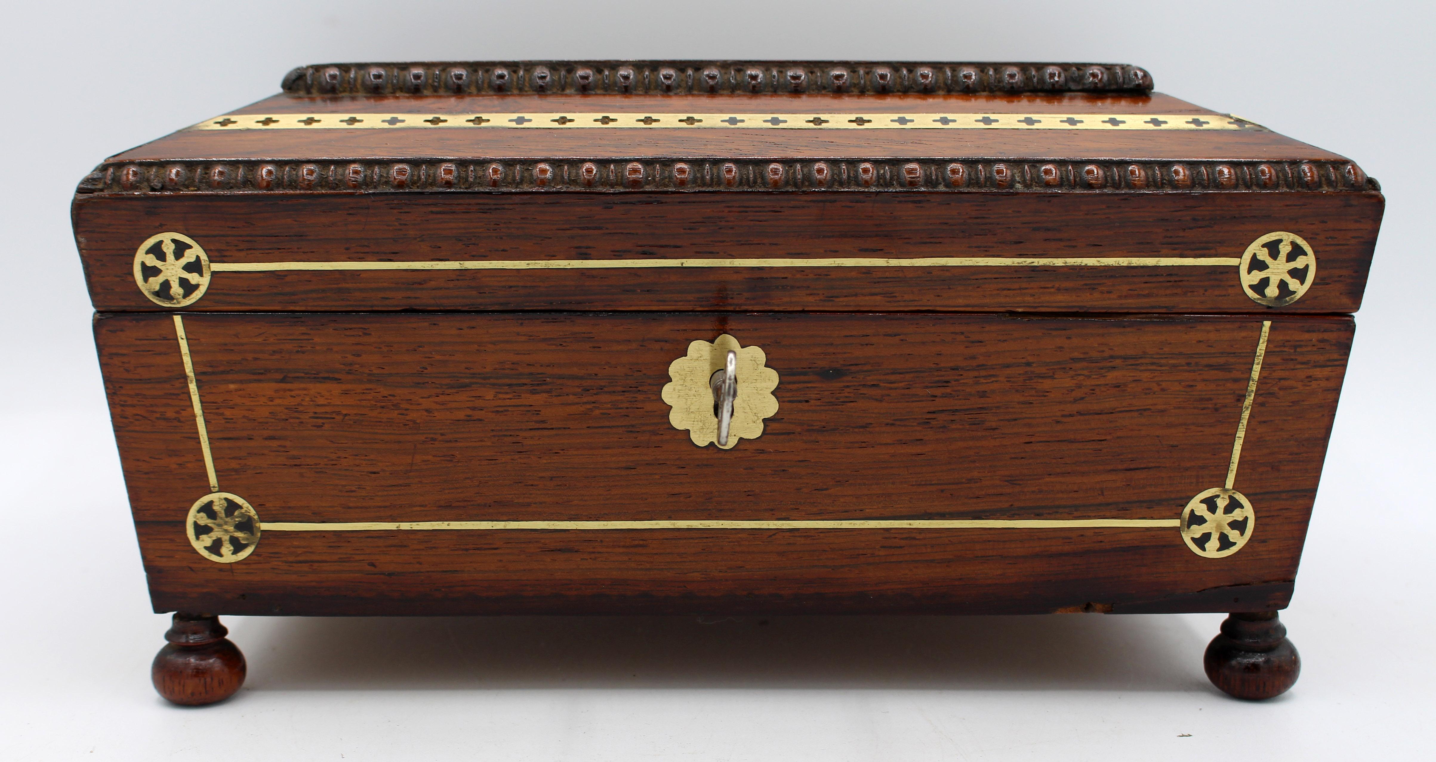Circa 1815-25 Regency brass inlaid work box, English. Superb quality with egg & dart moldings, extensive geometric, line & cutwork inlays & raised on bun feet. Bold monogram cartouche never engraved. Rosewood. Green paper lined interior lacks lift