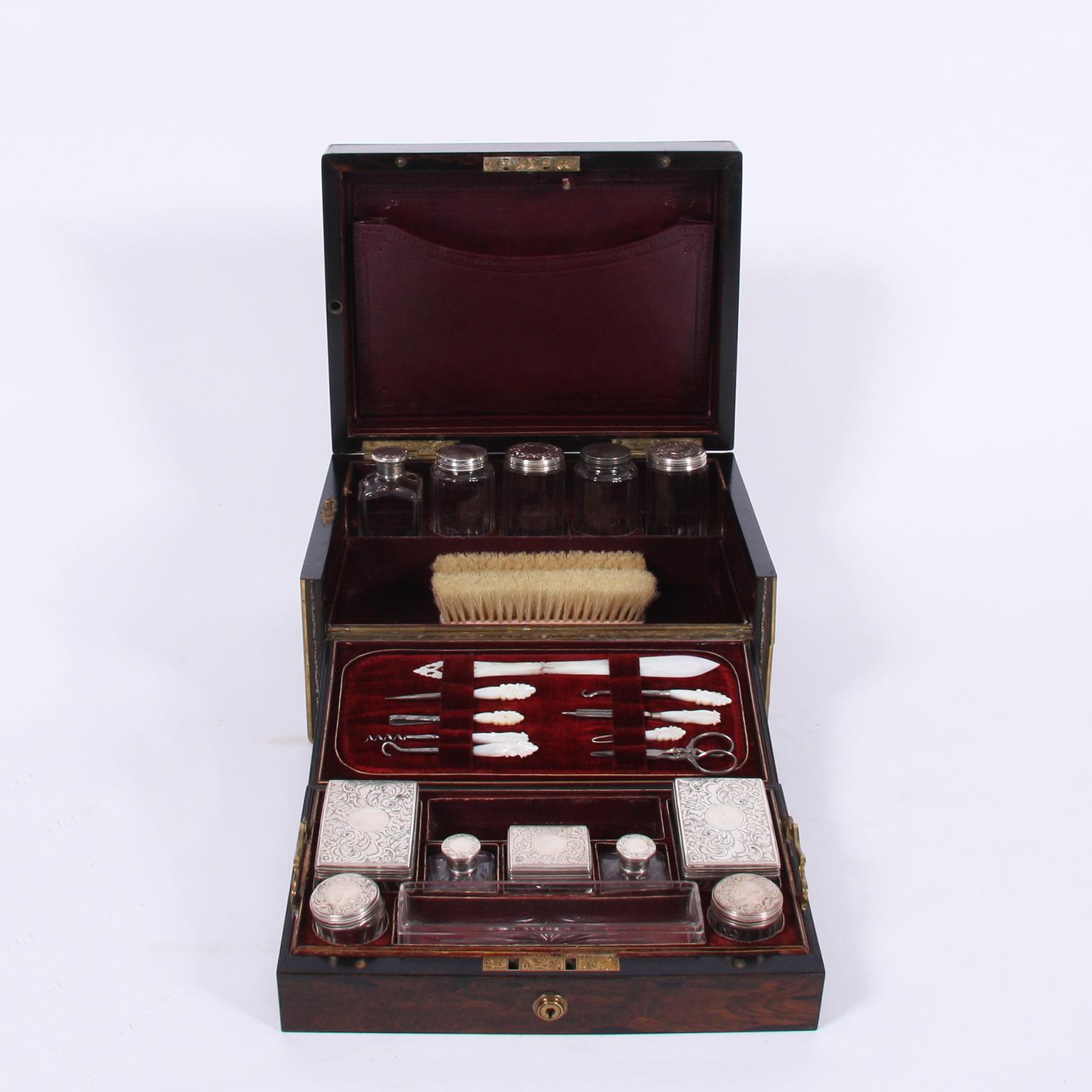 English, circa 1900

A stunning Coromandel vanity box. Lined in a stunning red velvet. Holds a set of silver topped, glass, bottles as well as a vanity tools set with mother of pearl handles. 

The vanity box possesses a letter compartment and