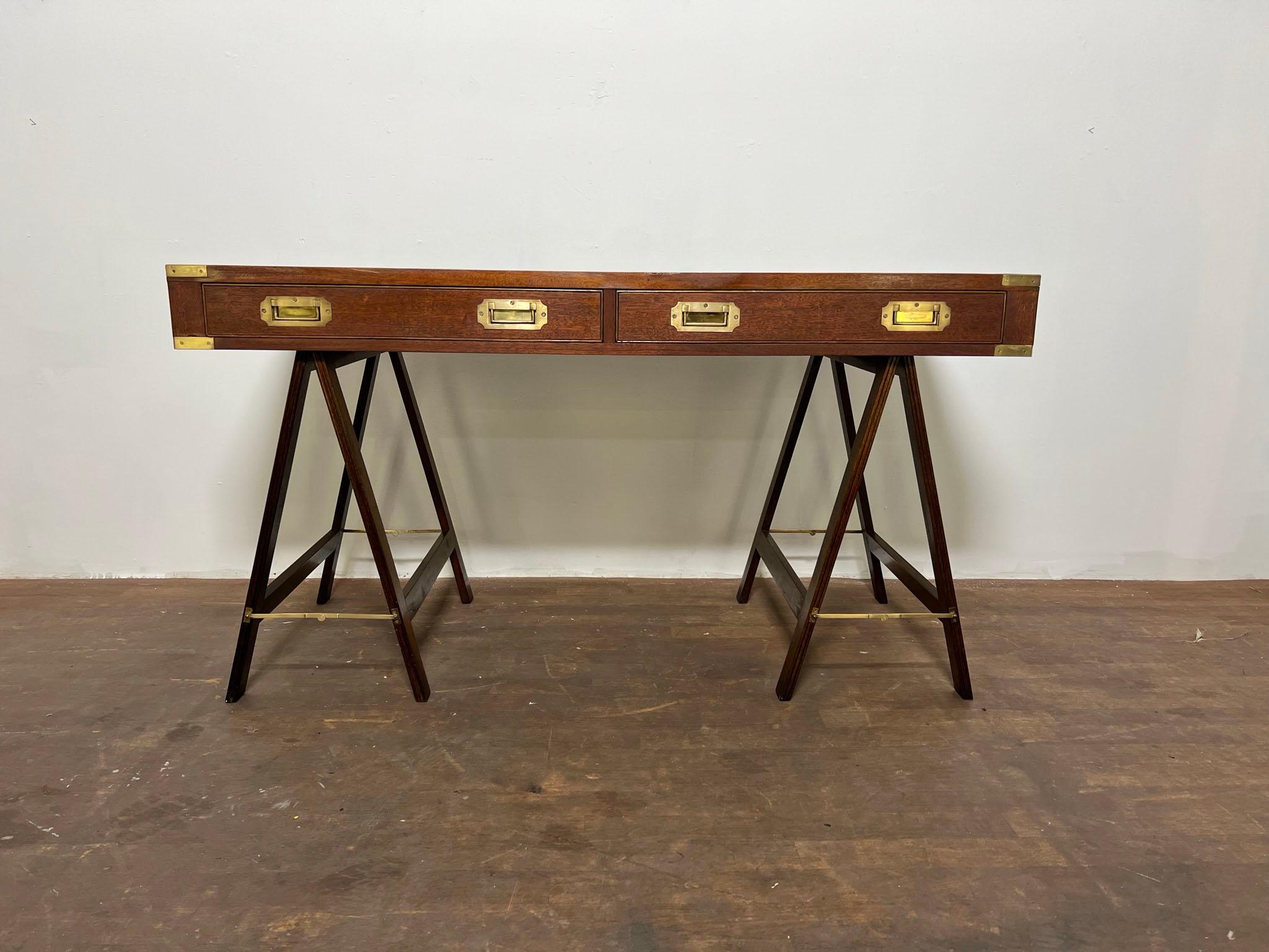 An English campaign desk in mahogany with leather top and solid brass hardware, circa 1950s..
